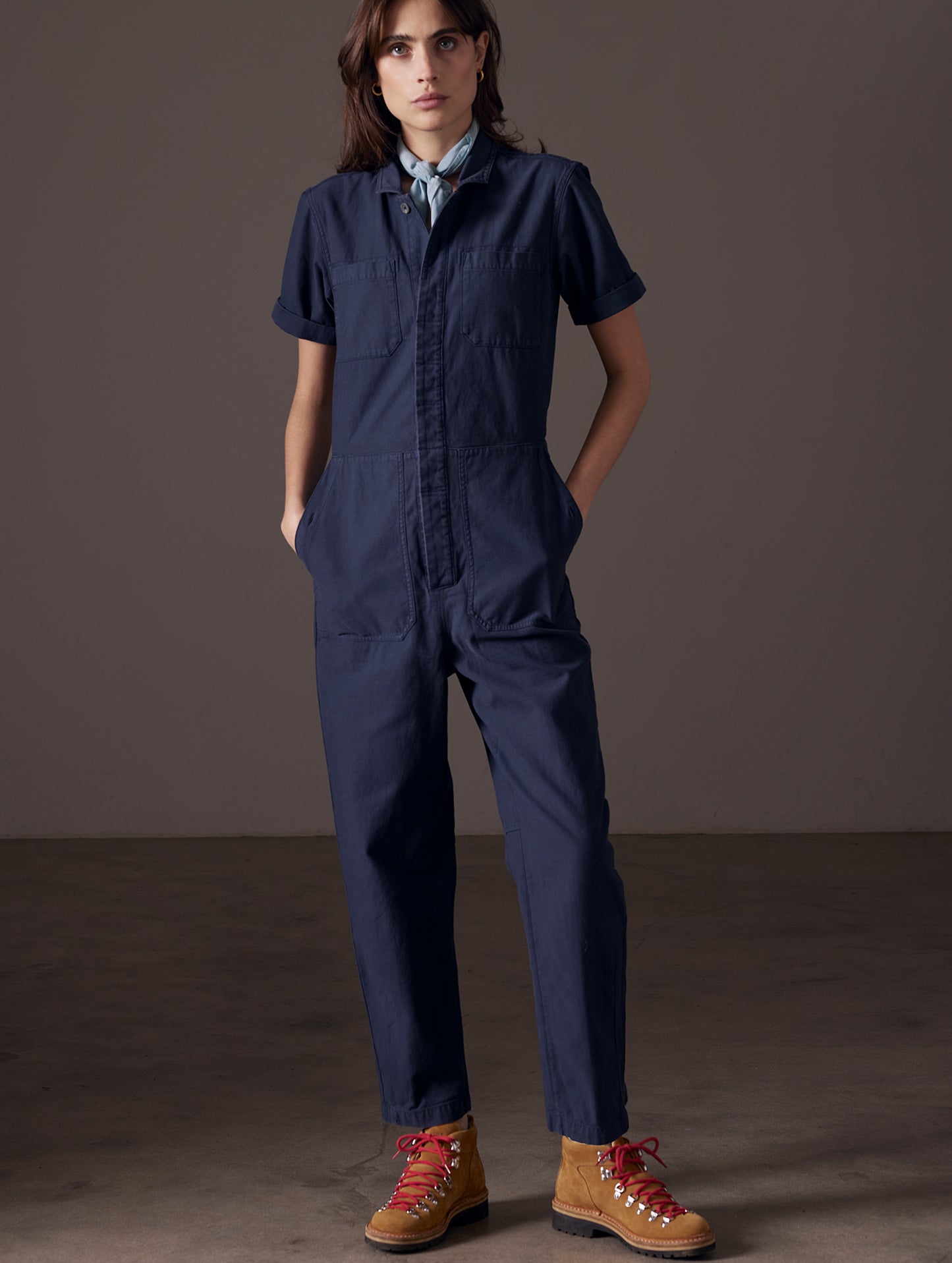Front full-body view of woman wearing Bard Jumpsuit in Total Eclipse dark blue from AETHER Apparel.