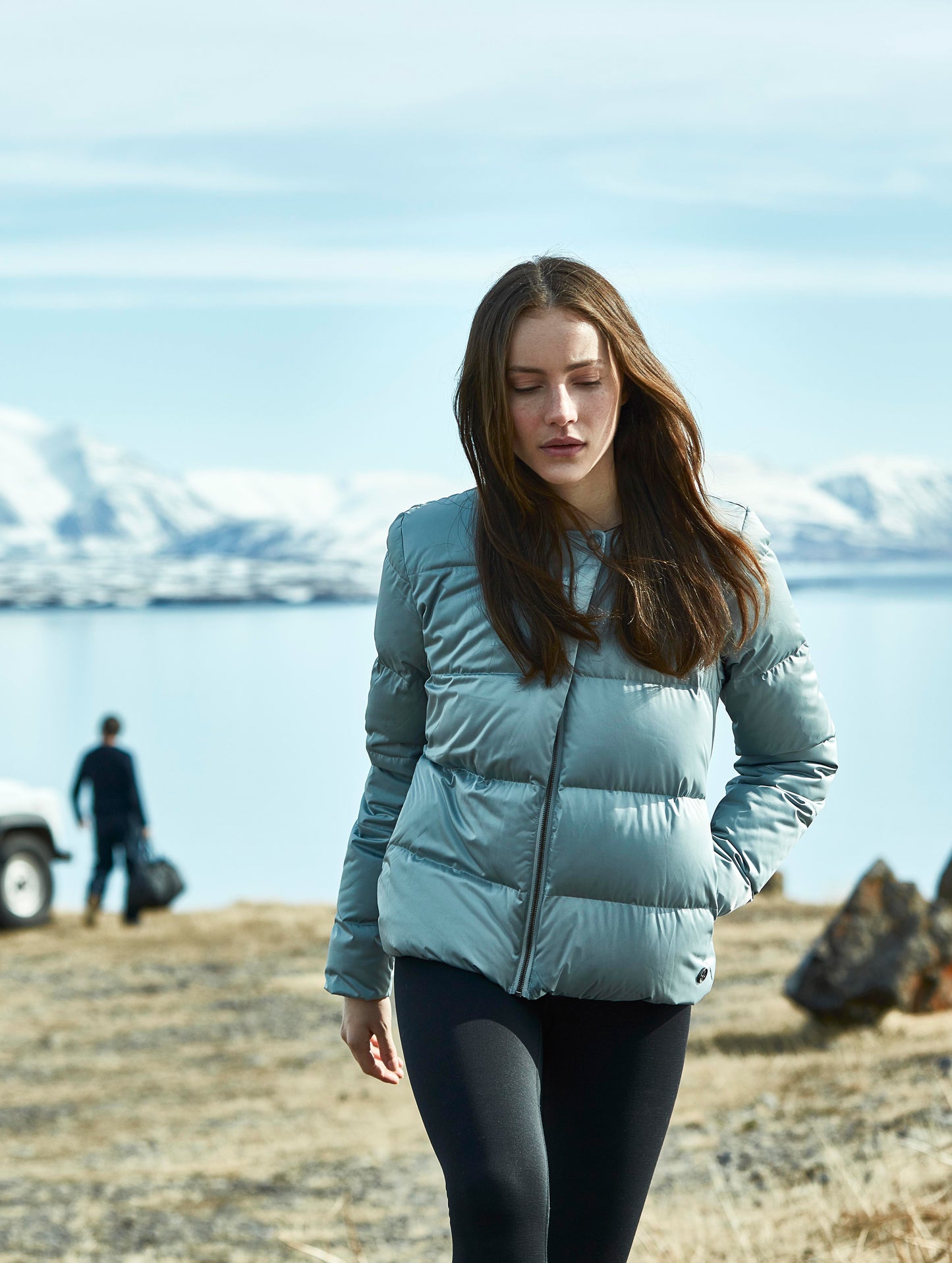 Woman walking outdoors wearing grey Brea Jacket from AETHER Apparel.