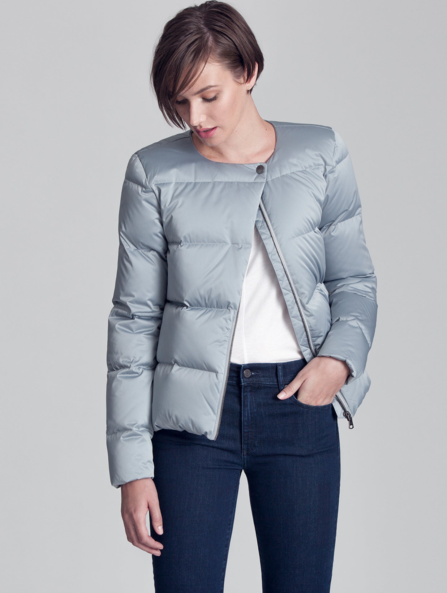 Woman indoors wearing grey Brea Jacket from AETHER Apparel.