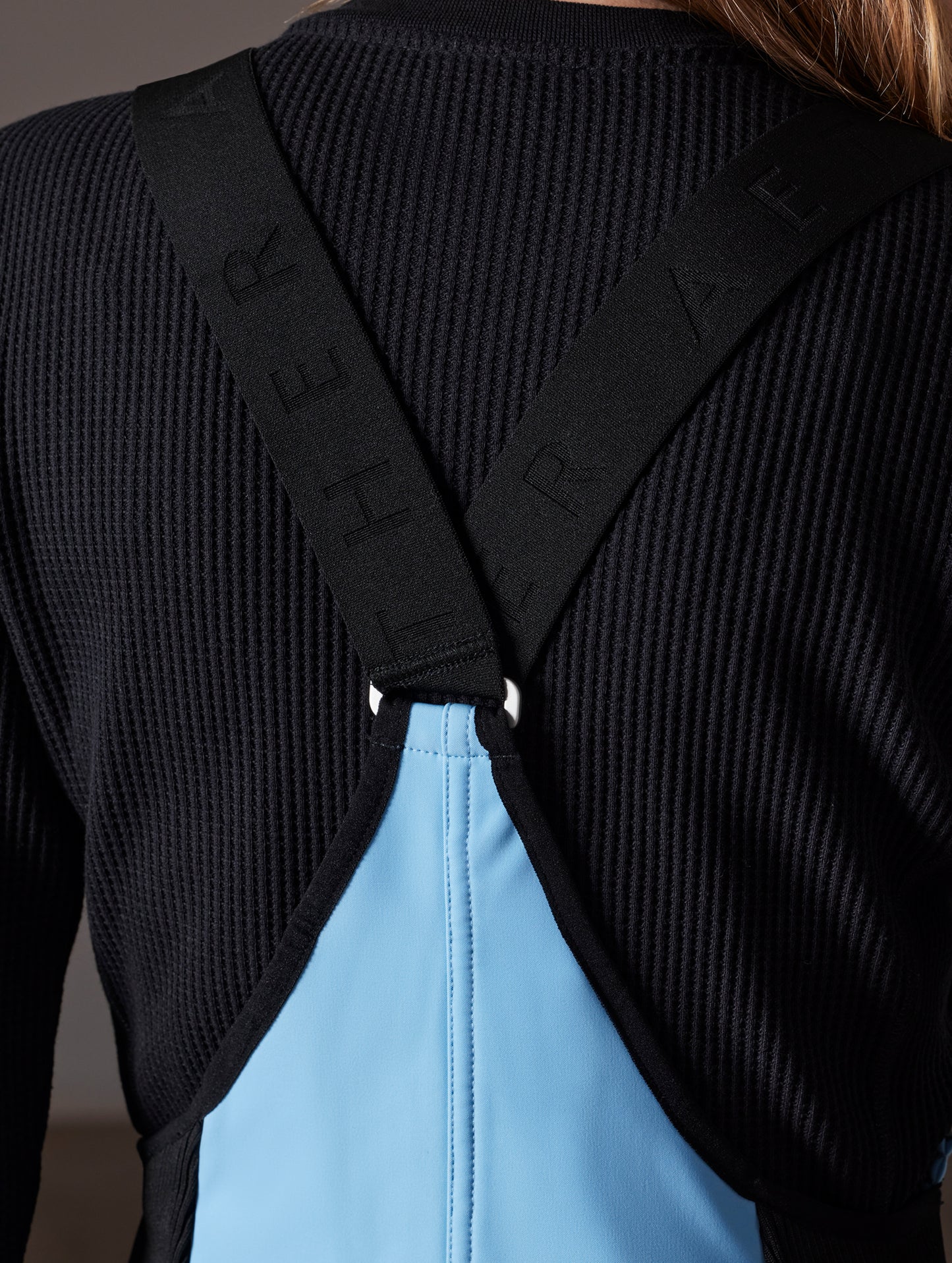 Closeup detailed view of back and shoulder straps of women's Descent Snow Bib 2.0 in Atlas Blue from AETHER Apparel.
