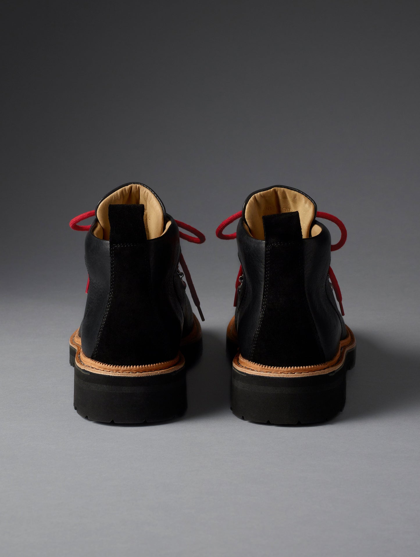 Rear view of women’s Dolomite Boot in Onyx Black from AETHER Apparel with red laces.