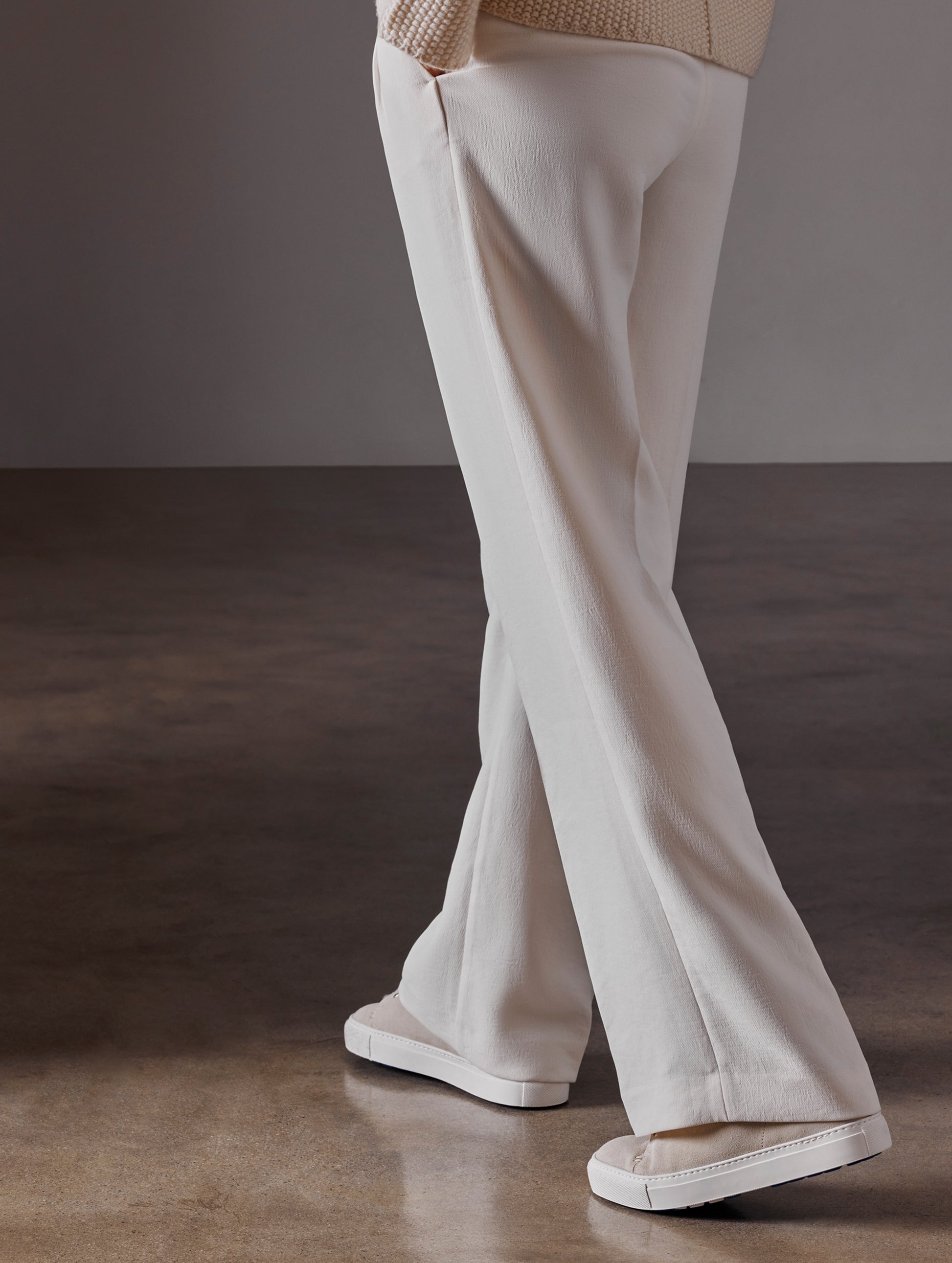 Rear angled lower body view of woman wearing Durham Sneaker with Shearling in Bone white from AETHER Apparel.