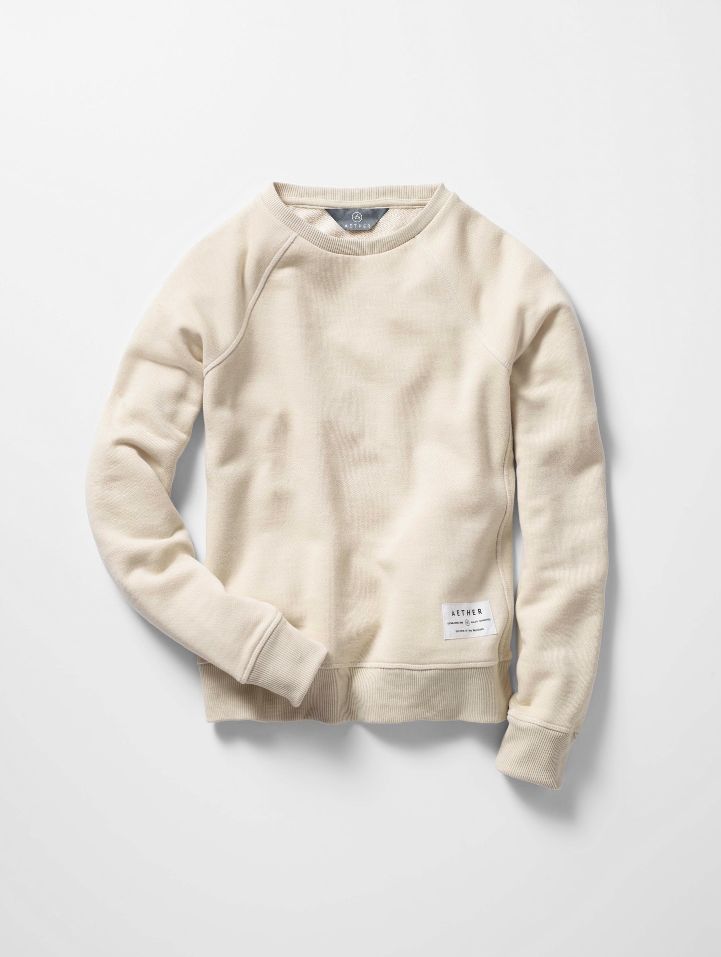 Flat lay of women's Foundation Raglan Sweatshirt in Bone white from AETHER Apparel.