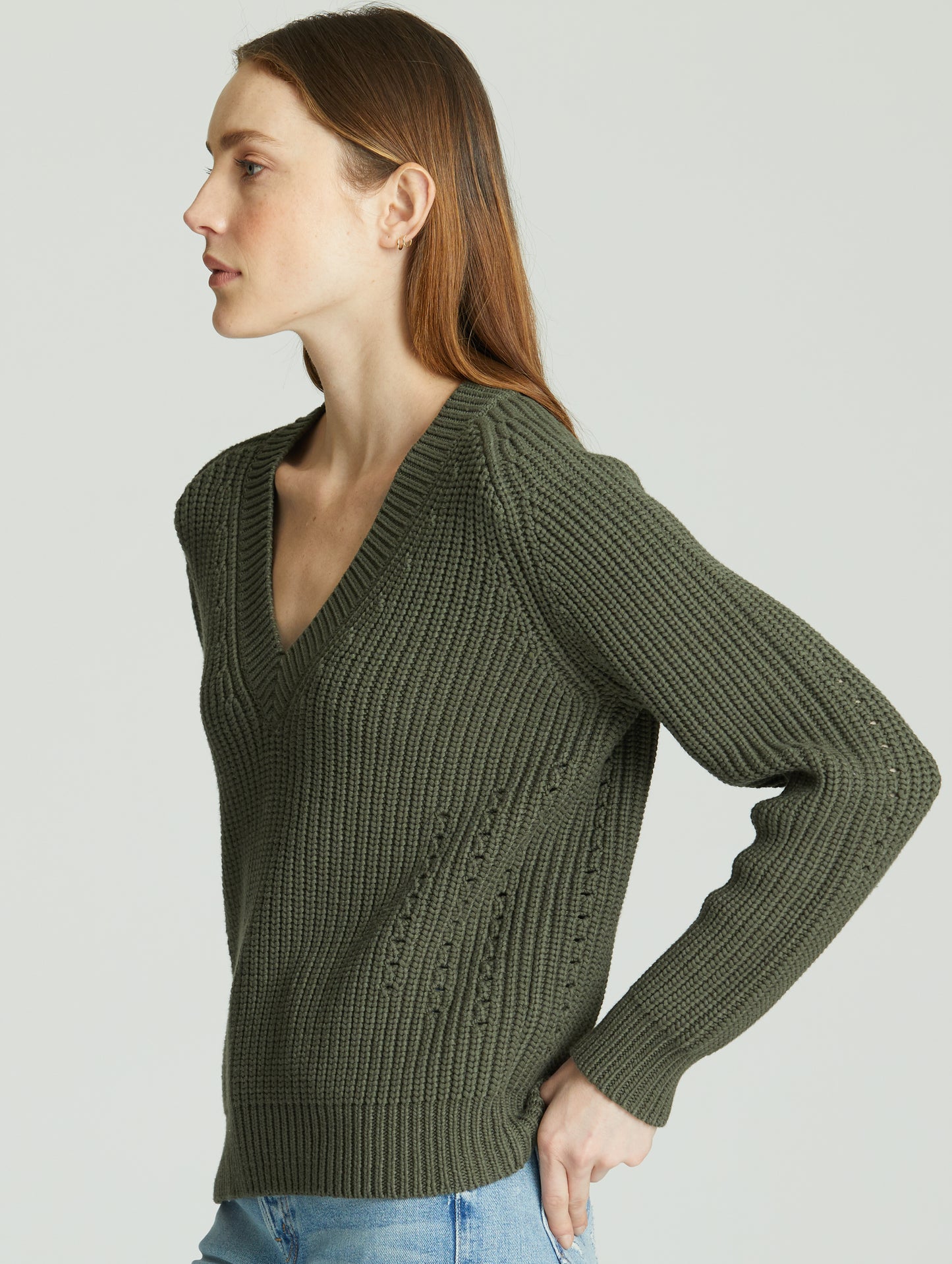 Angled view of woman wearing green Keaton Sweater from AETHER Apparel.
