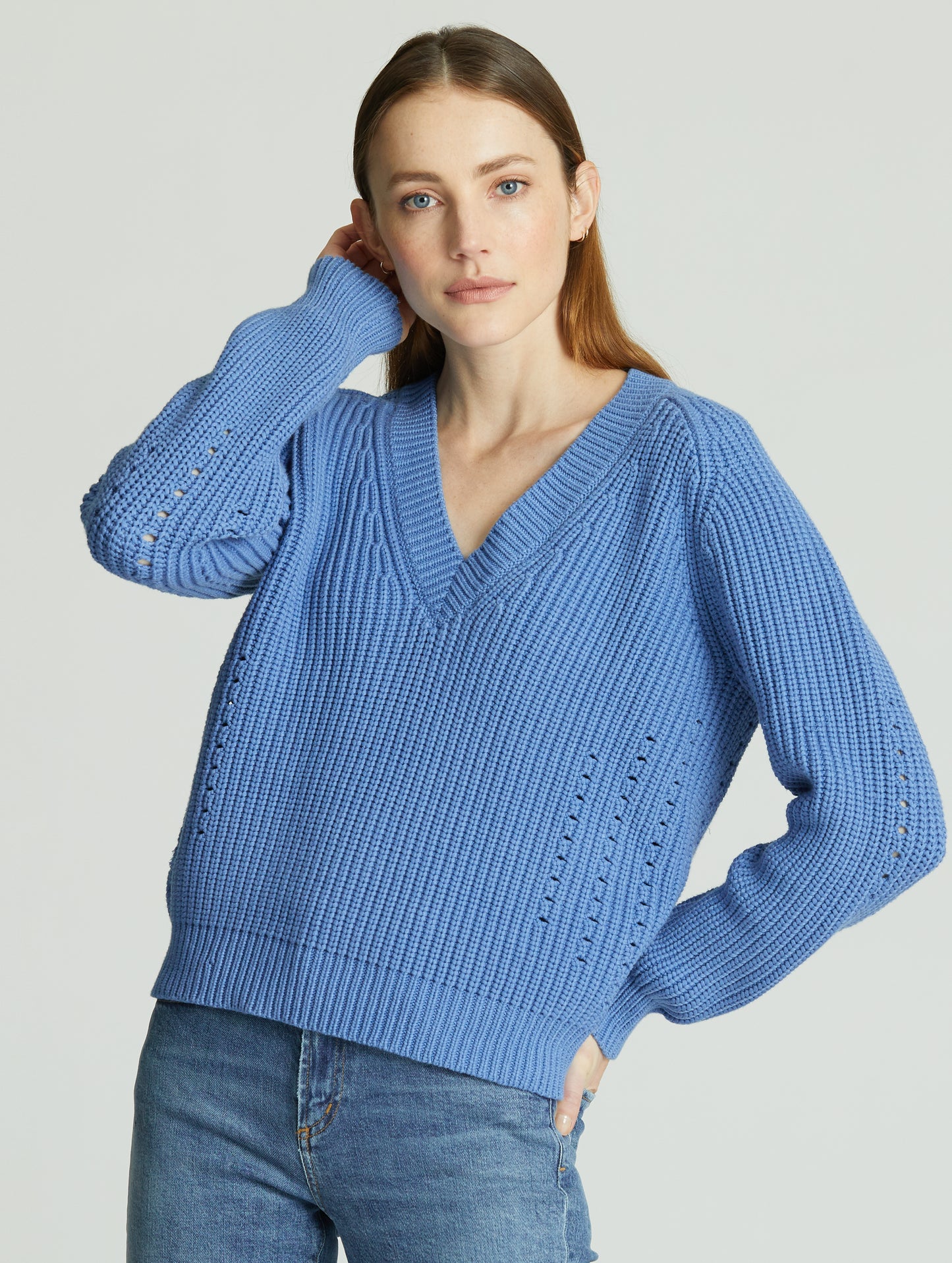 Woman indoors wearing light blue Keaton Sweater from AETHER Apparel.