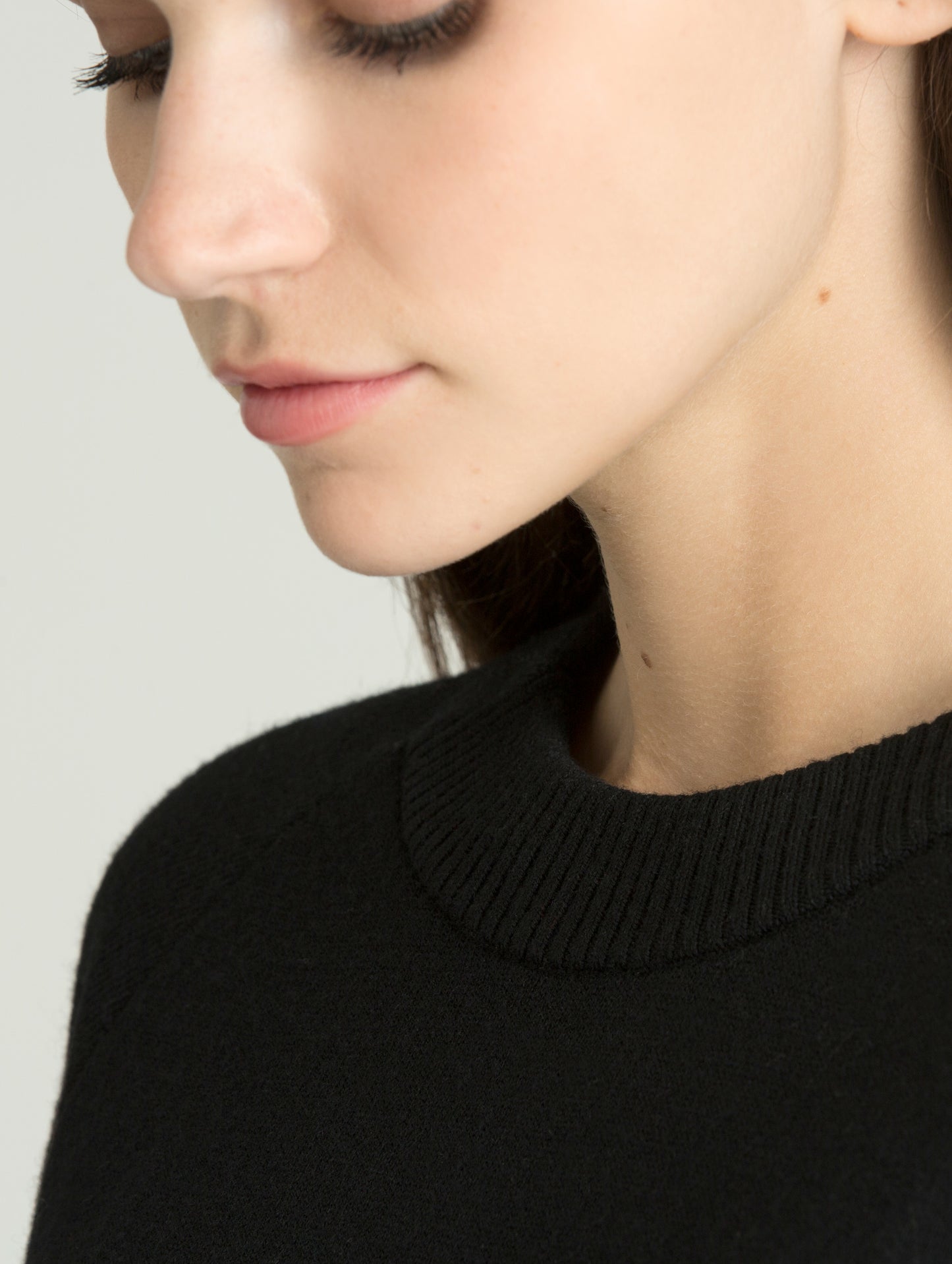 Closeup detailed view of knitted collar on women's Racer Sweater in Onyx Black from AETHER Apparel.