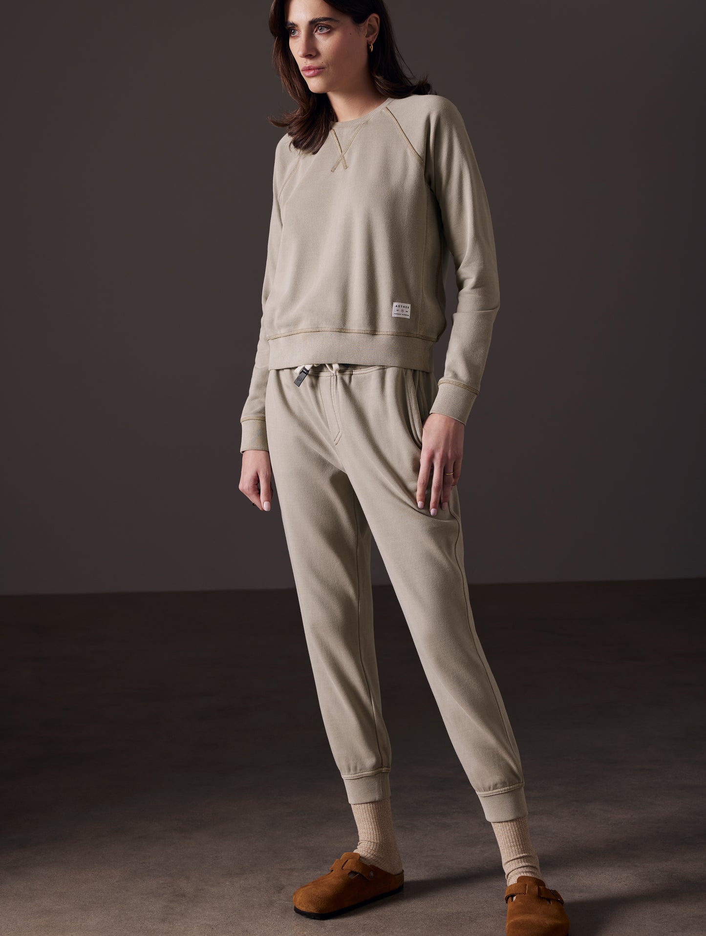 Front angled full-body view of woman wearing Solstice Lightweight Jogger in Laurel Grey from AETHER Apparel.