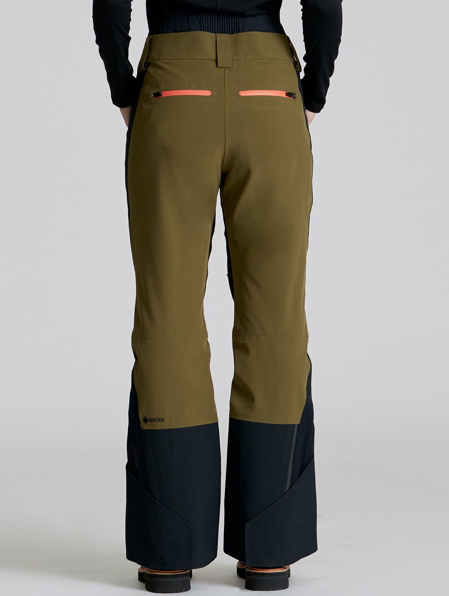 Rear lower body view of woman wearing Stealth Snow Pant in Command Green and Onyx Black from AETHER Apparel.