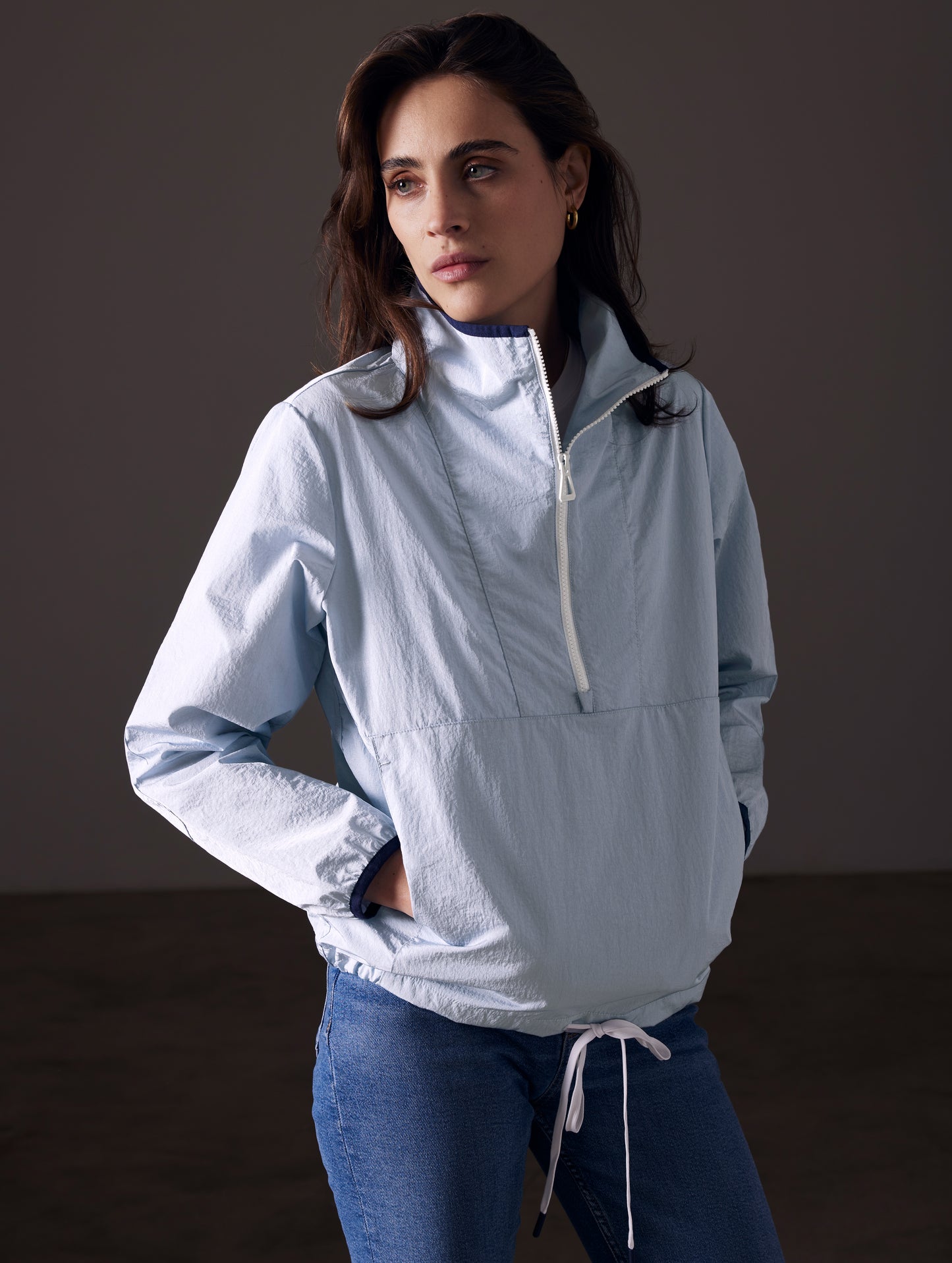 Front angled view of woman wearing Topanga Lightweight Anorak in Flight Blue from AETHER Apparel.