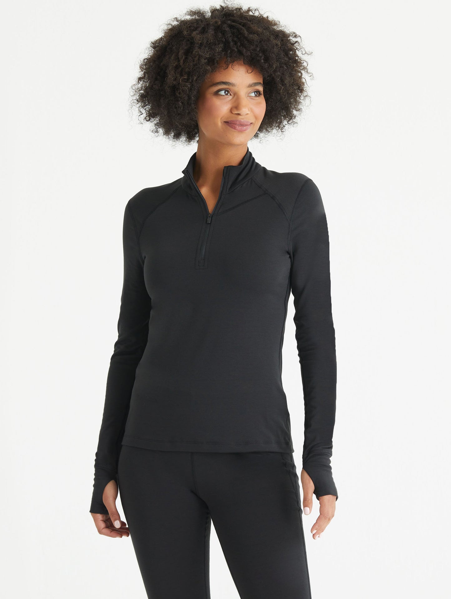 Woman wearing black Vapor Half-Zip Base Layer Jacket from AETHER Apparel.
