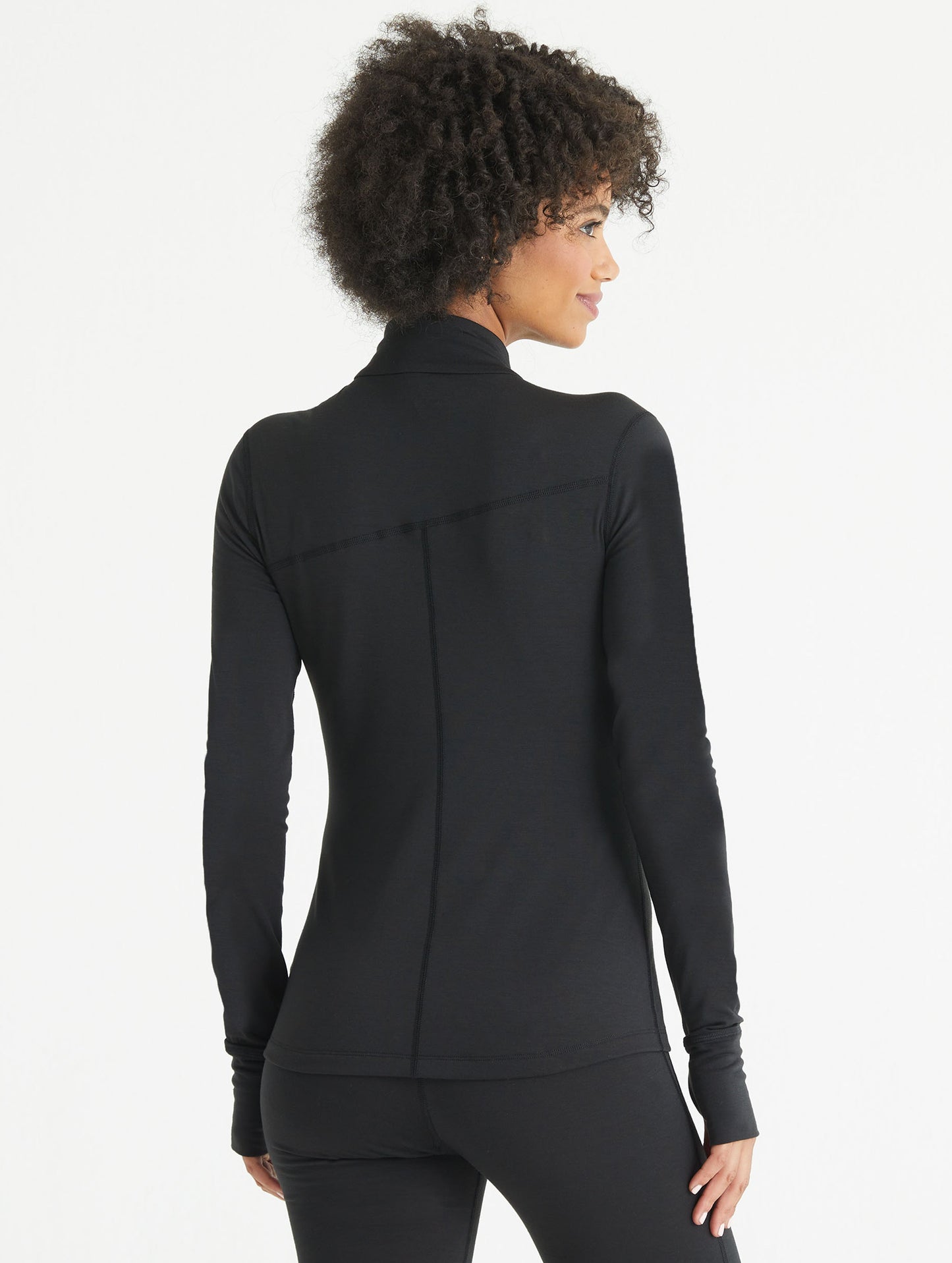 Back view of woman wearing black Vapor Half-Zip Base Layer Jacket from AETHER Apparel.