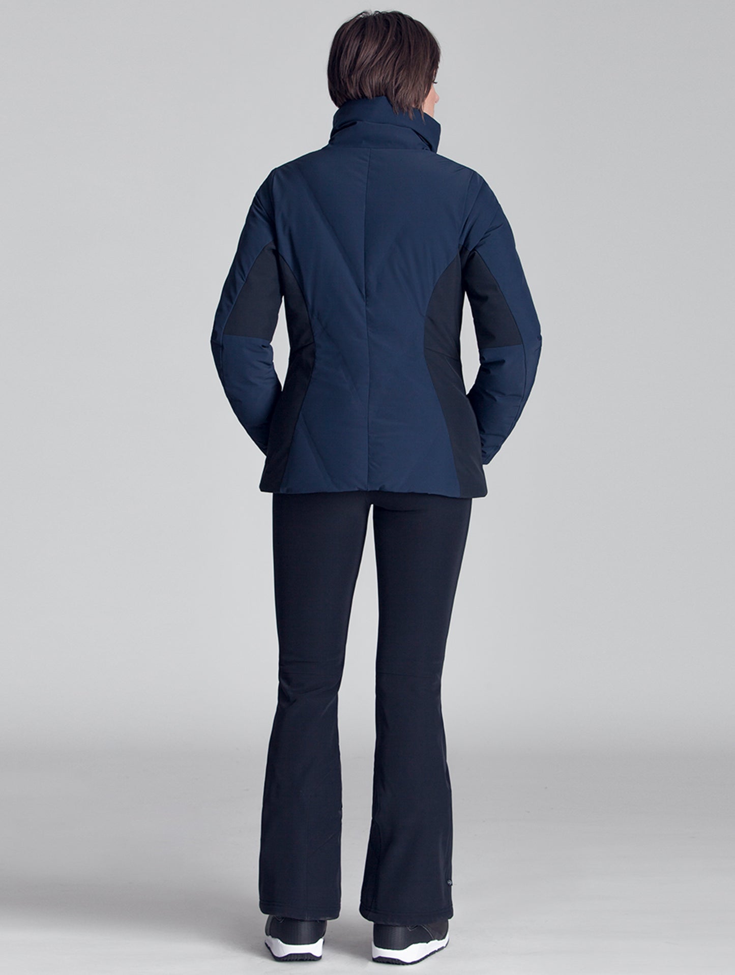 Back view of woman wearing blue Vertical Jacket from AETHER Apparel.