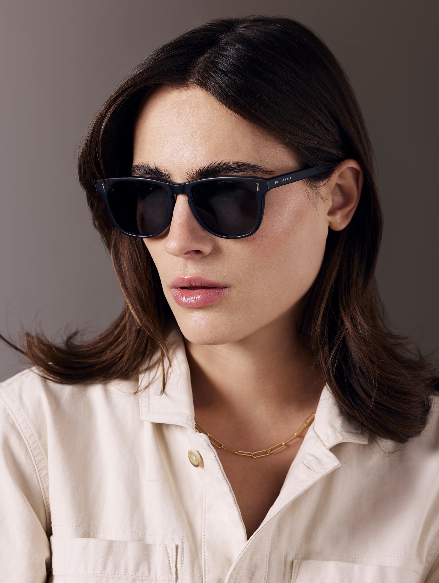 Front 3/4 view of woman wearing Yosemite Sunglass in Matte Black with Grey Lens from AETHER Apparel.