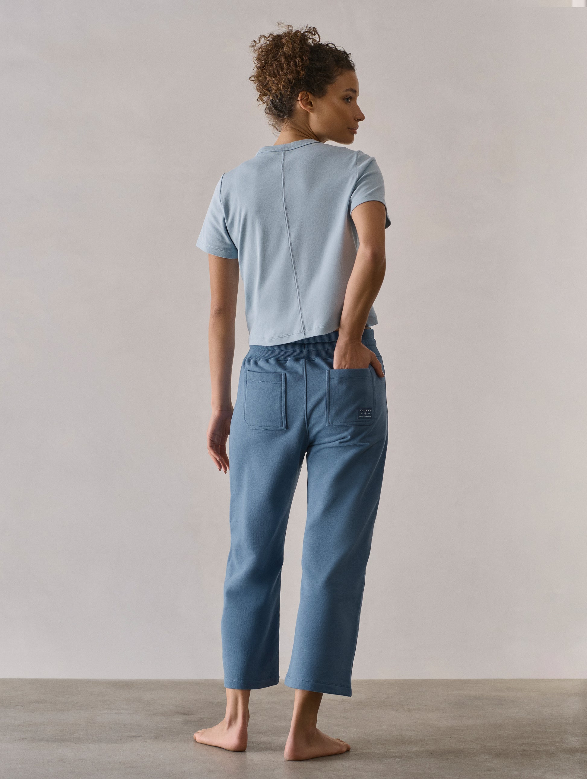 Rear full-body view of woman wearing W Osa Cropped Sweatpant in Coastal Blue from AETHER Apparel.