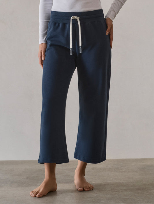 Front full-body view of woman wearing W Osa Cropped Sweatpant in Total Eclipse dark blue from AETHER Apparel.