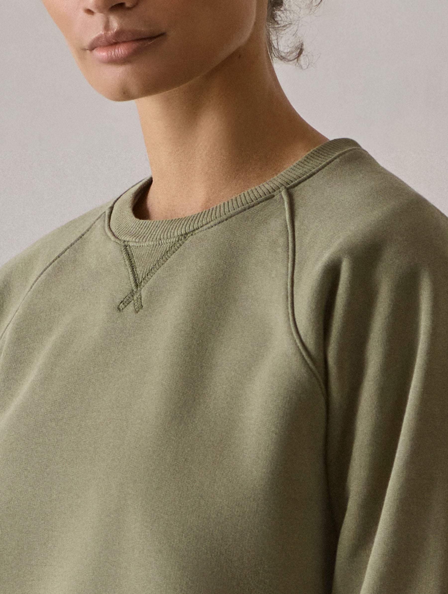 Closeup detailed view of the triangle rib inset and raglan sleeve construction on the W Osa Raglan Sweatshirt in Fern Green from AETHER Apparel.
