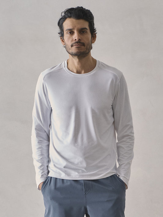 Front upper-body view of man wearing Adventure Performance Long-Sleeve Tee in White from AETHER Apparel.