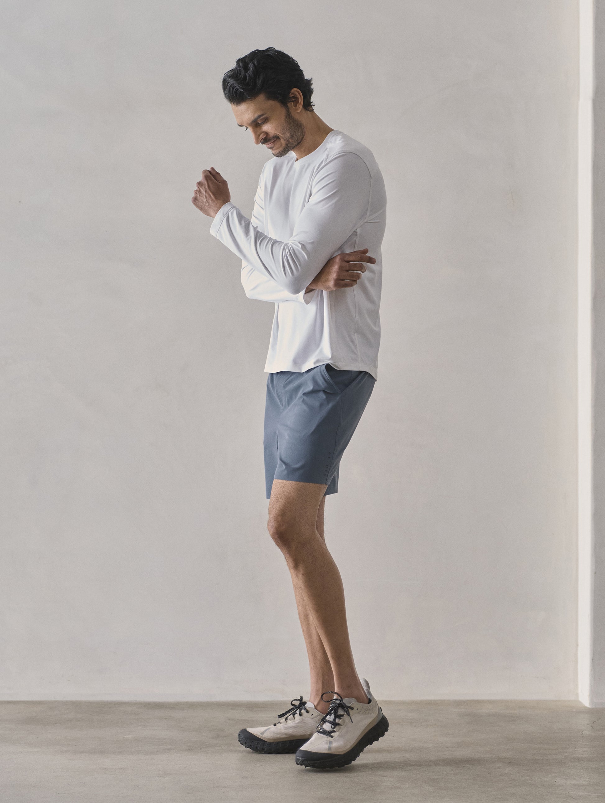Front 3/4 full-body view of man wearing Adventure Performance Long-Sleeve Tee in White from AETHER Apparel.