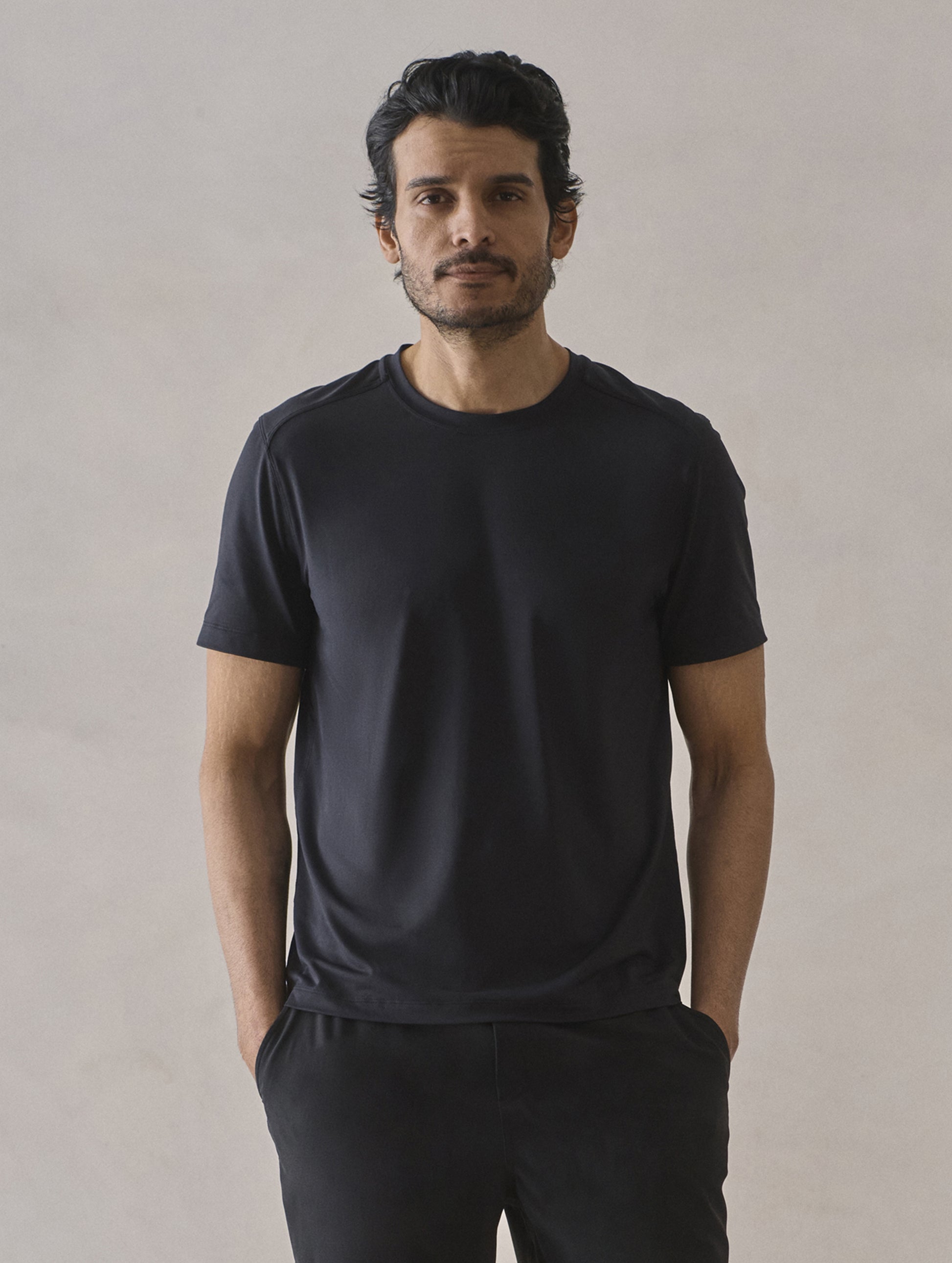 Front upper-body view of man wearing Adventure Performance Short-Sleeve Tee in Onyx Black from AETHER Apparel.