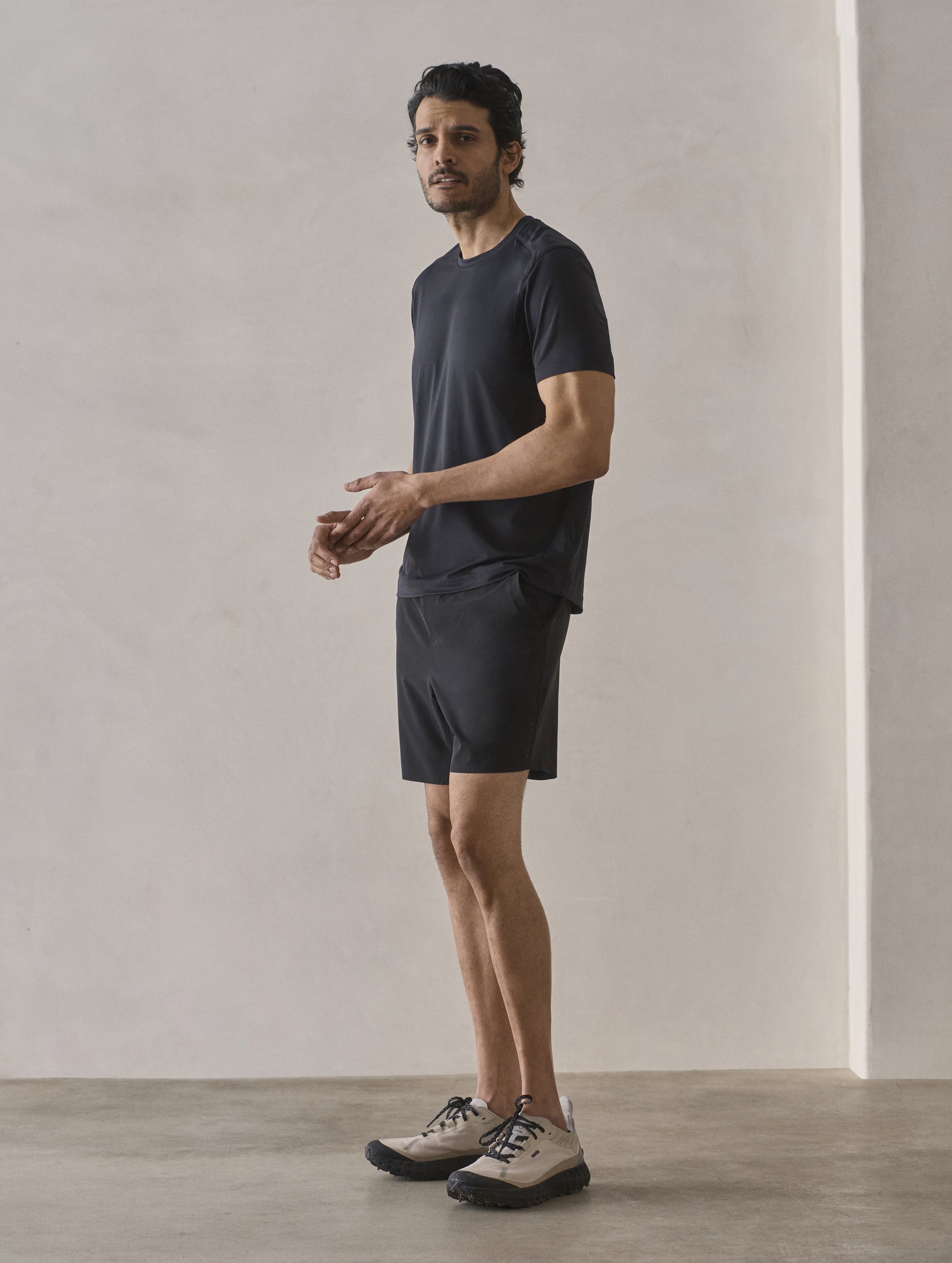 Front 3/4 full-body view of man wearing Adventure Performance Short-Sleeve Tee in Onyx Black from AETHER Apparel.