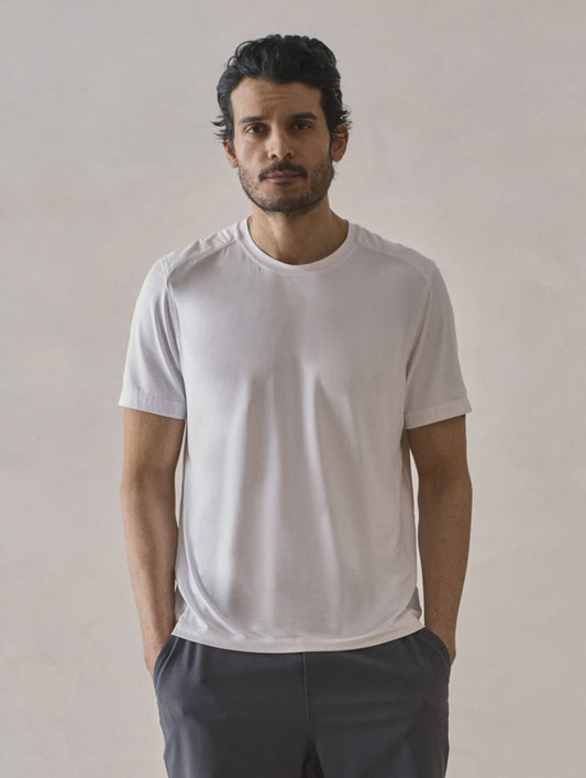 Front upper-body view of man wearing Adventure Performance Short-Sleeve Tee in White from AETHER Apparel.