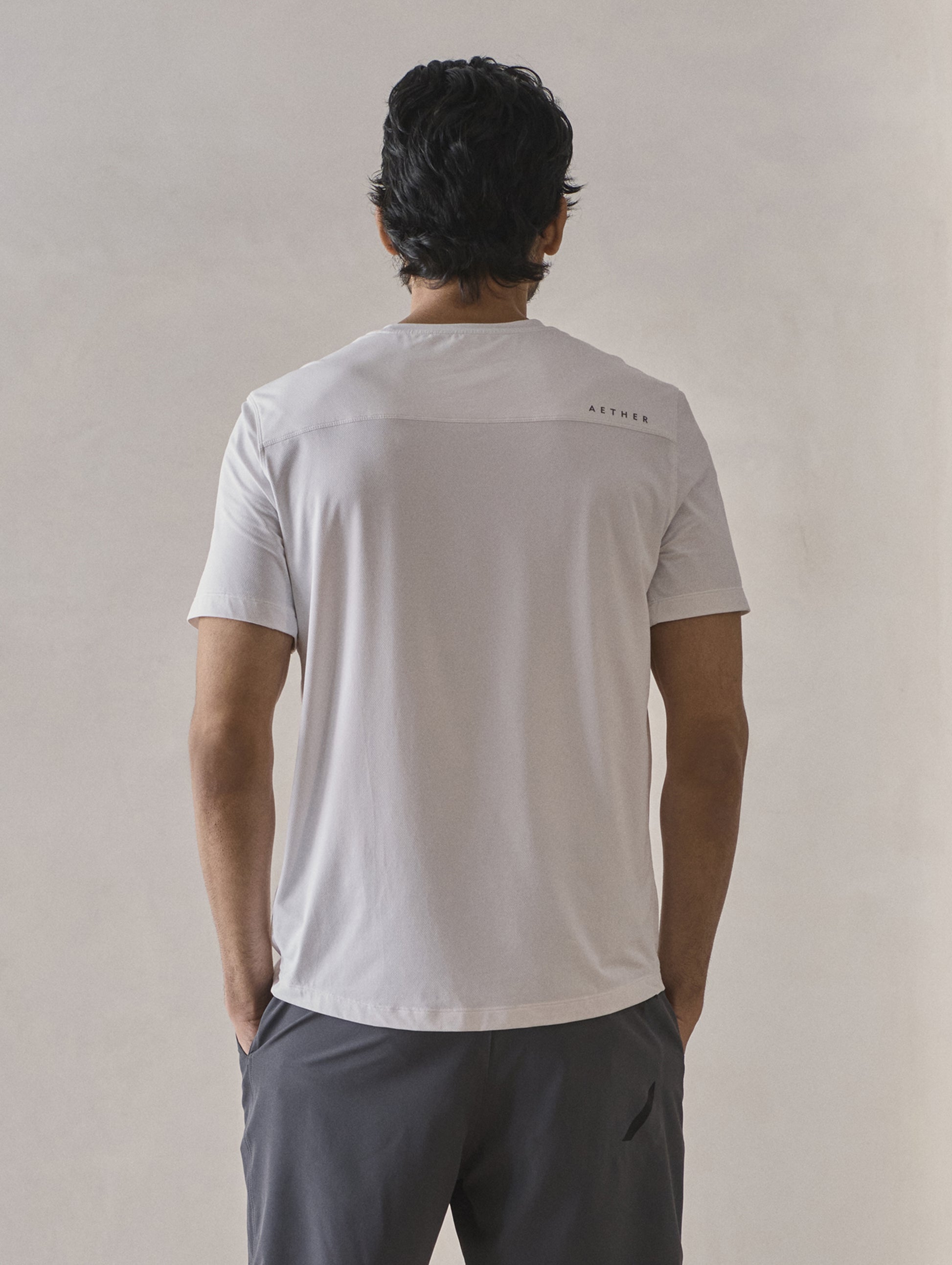 Rear upper-body view of man wearing Adventure Performance Short-Sleeve Tee in White from AETHER Apparel.