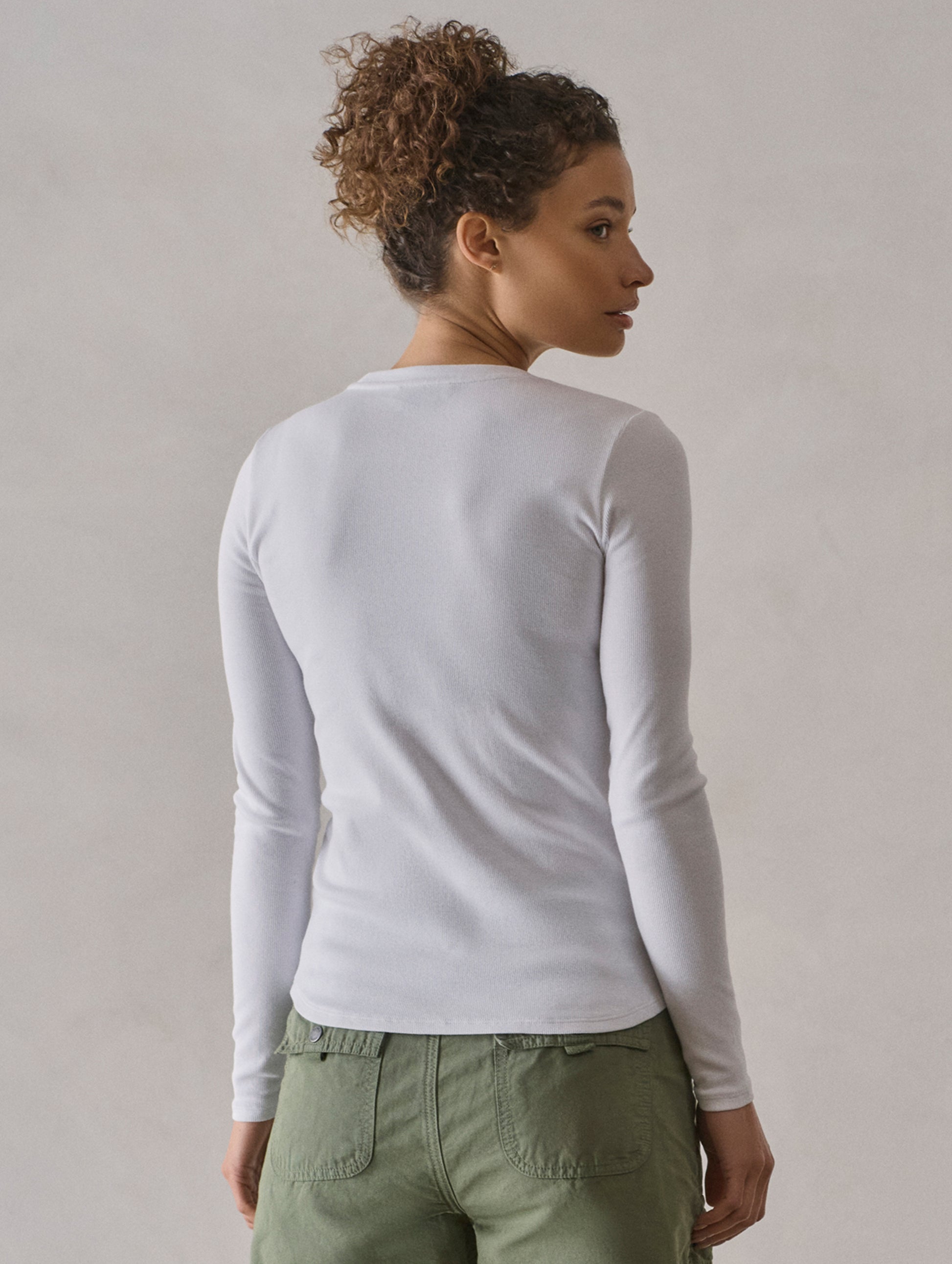 Rear view of woman wearing Amara Long-Sleeve Crew in White from AETHER Apparel.