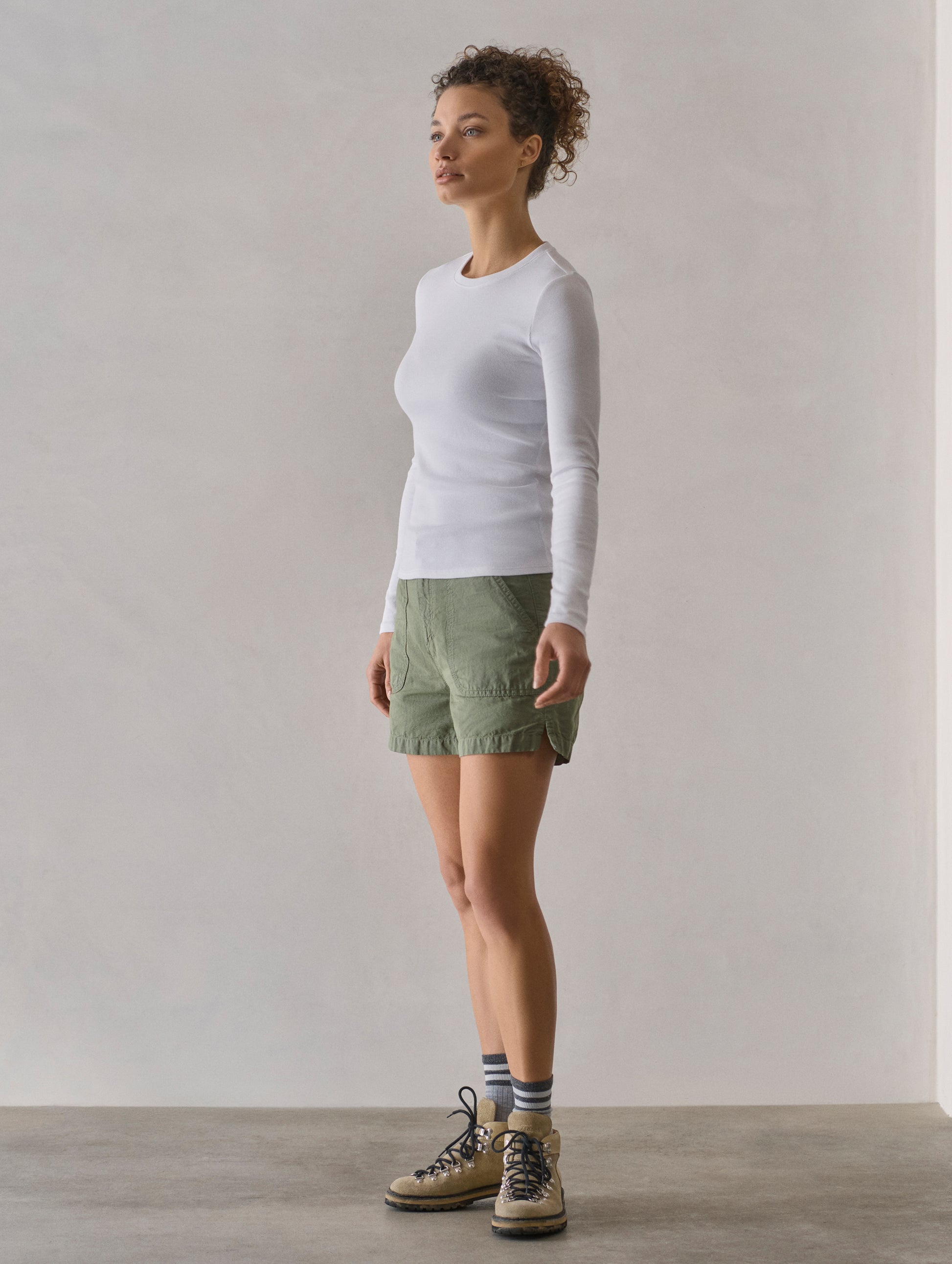 Front 3/4 full-body view of woman wearing Amara Long-Sleeve Crew in White from AETHER Apparel.