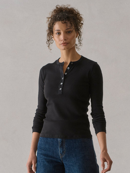 Front view of woman wearing Amara Long-Sleeve Ribbed Henley in Onyx Black from AETHER Apparel.