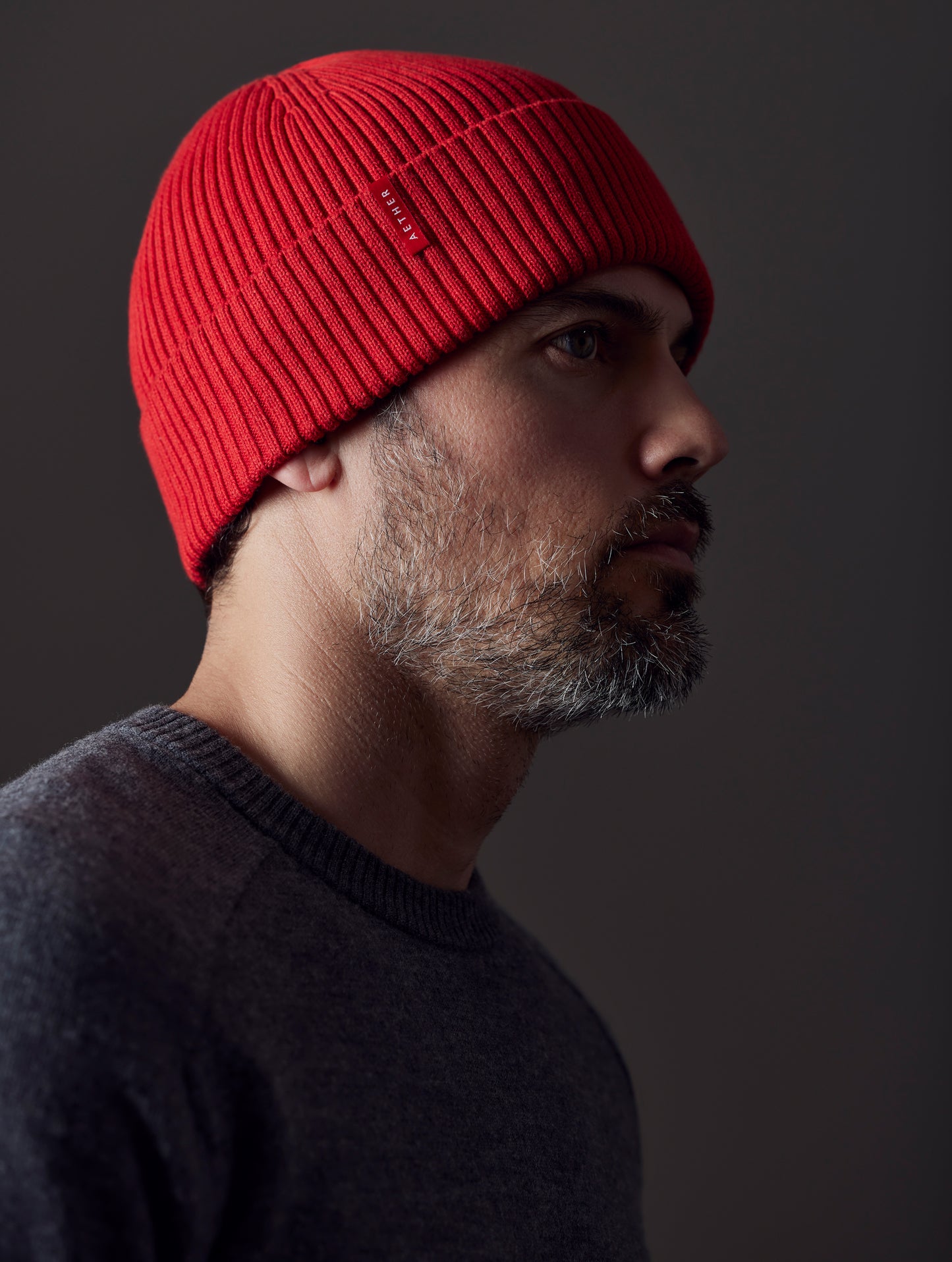 man wearing red cotton beanie from AETHER Apparel