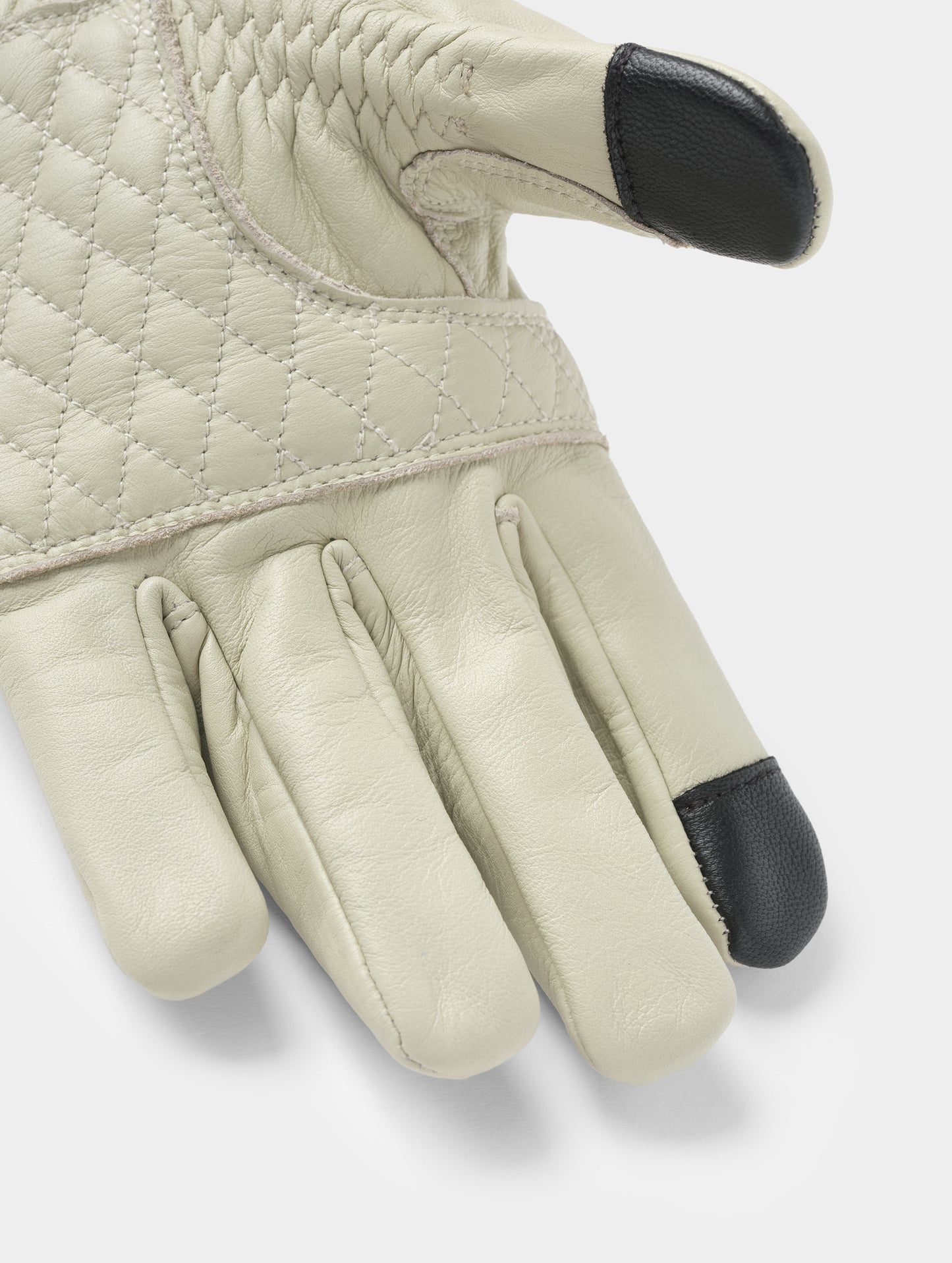 Closeup detailed view of the diamond-quilted palm and conductive thumb and pointer fingertips on the Circuit Moto Glove in Basalt from AETHER Apparel.