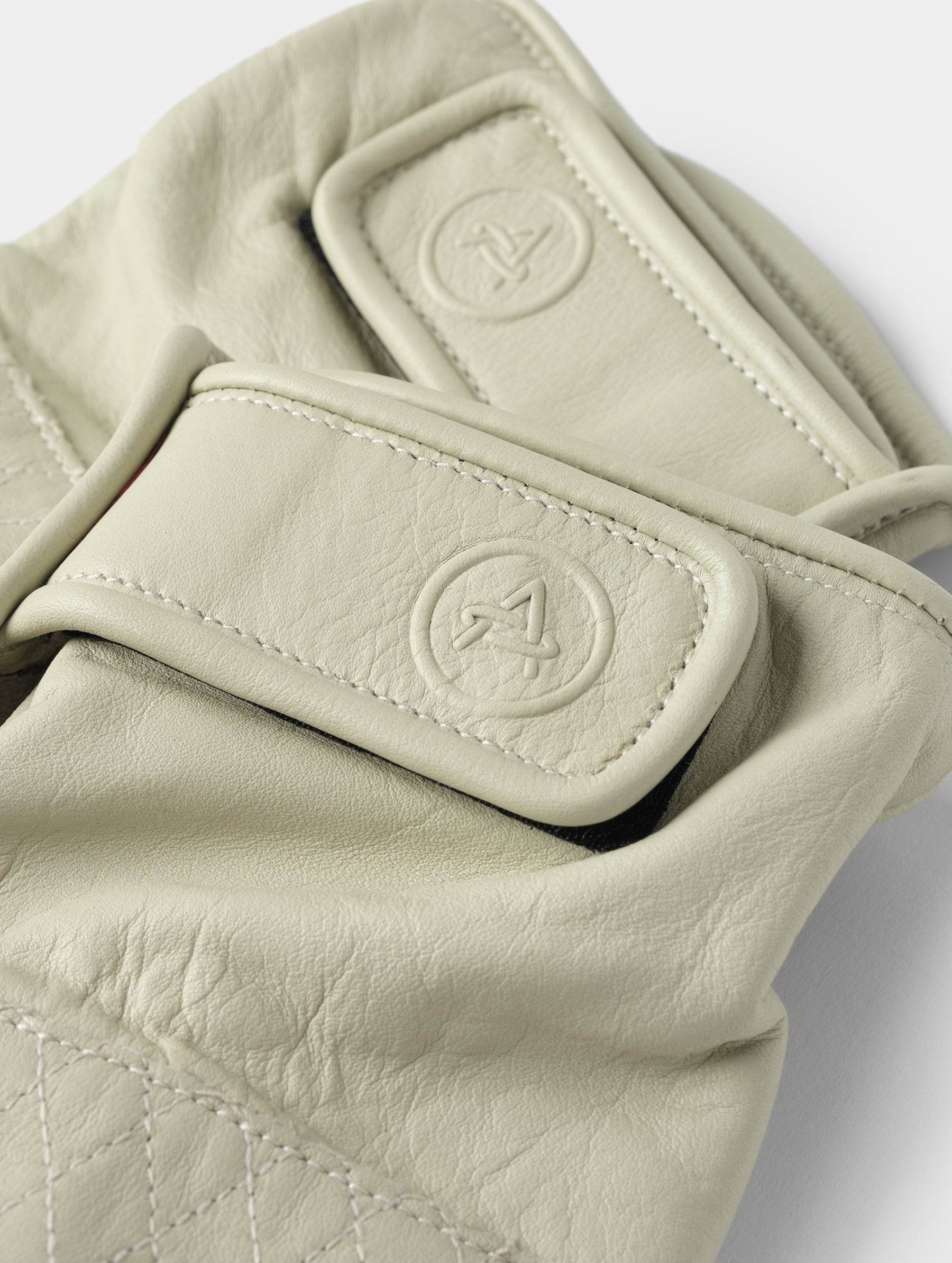 Closeup detailed view of the elasticated wrist and embossed AETHER-branded Velcro pull tab on the Circuit Moto Glove in Basalt from AETHER Apparel.