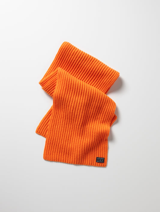 Flat lay of Ribbed Cashmere Scarf in Bitter Orange from AETHER Apparel. 