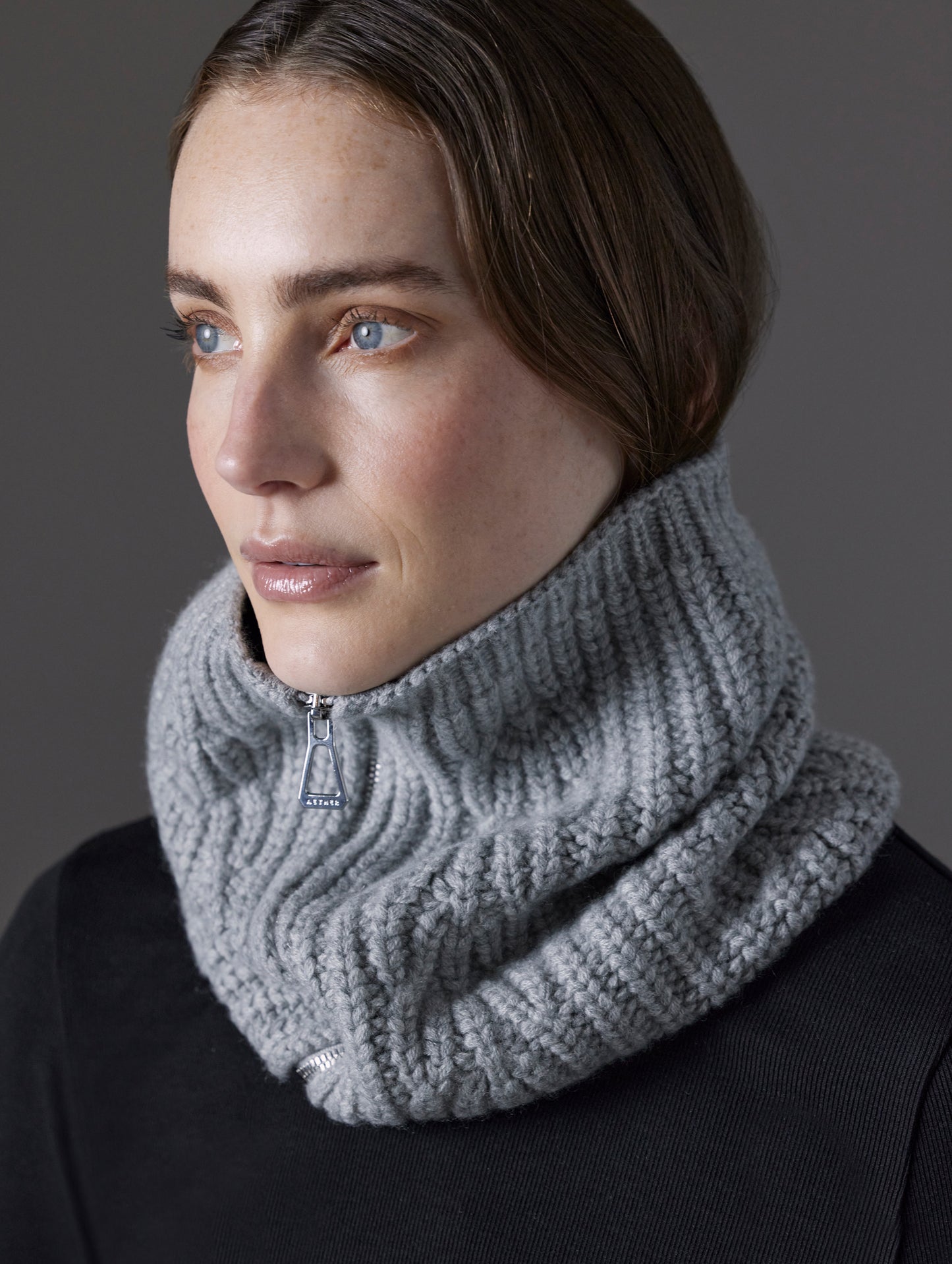 Front angled view of woman wearing Sweater Neck Gaiter 2.0 in Light Heather Grey from AETHER Apparel. 