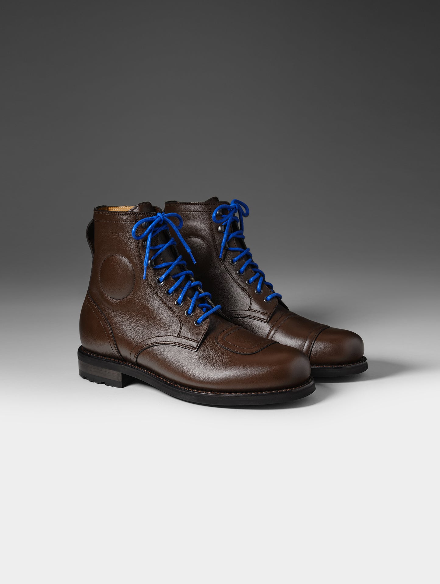 Front 3/4 studio shot of the Tioga Moto Boot in Espresso Brown with blue laces from AETHER Apparel.