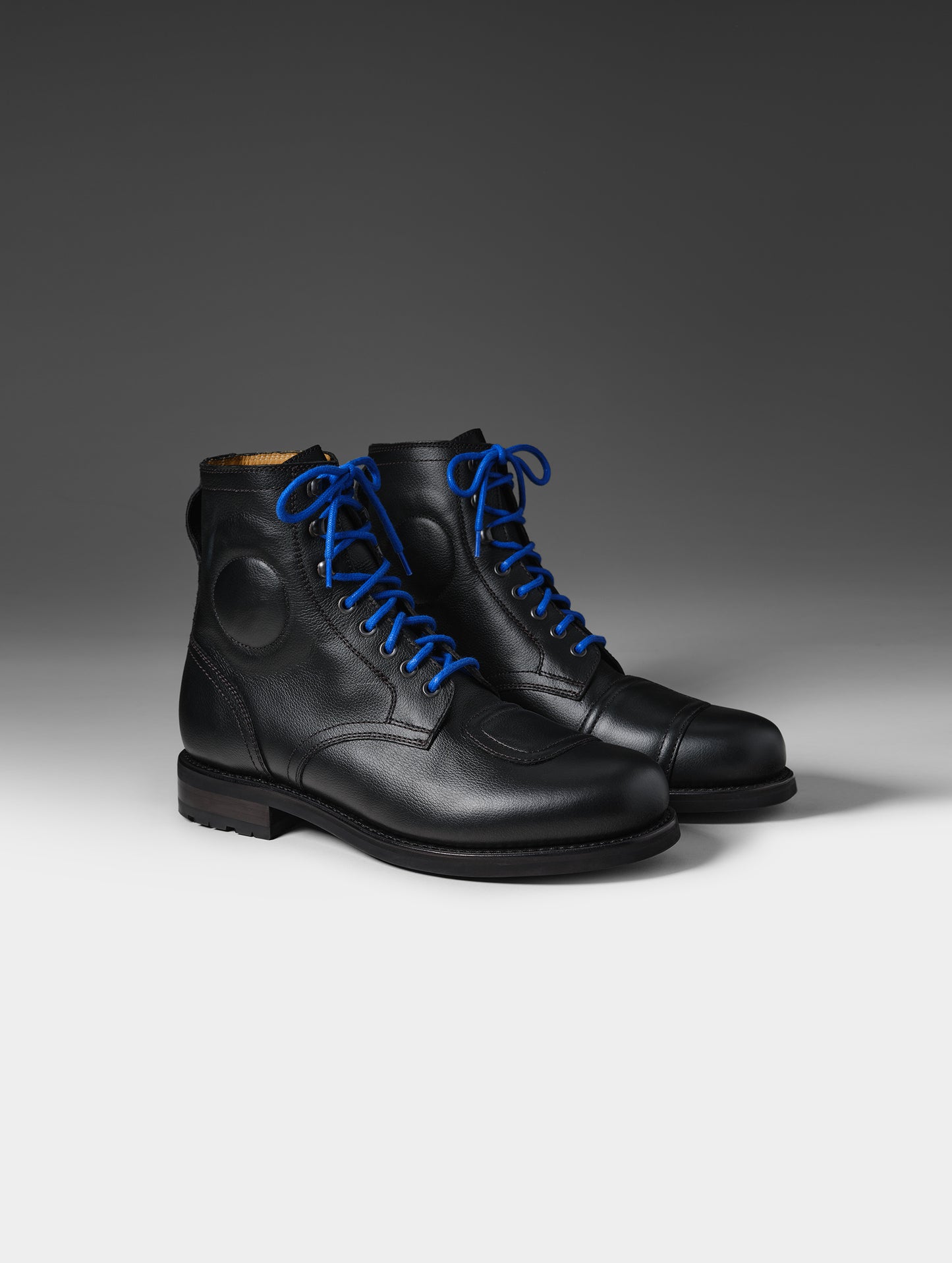 Front 3/4 studio shot of the Tioga Moto Boot in Onyx Black with blue laces from AETHER Apparel.