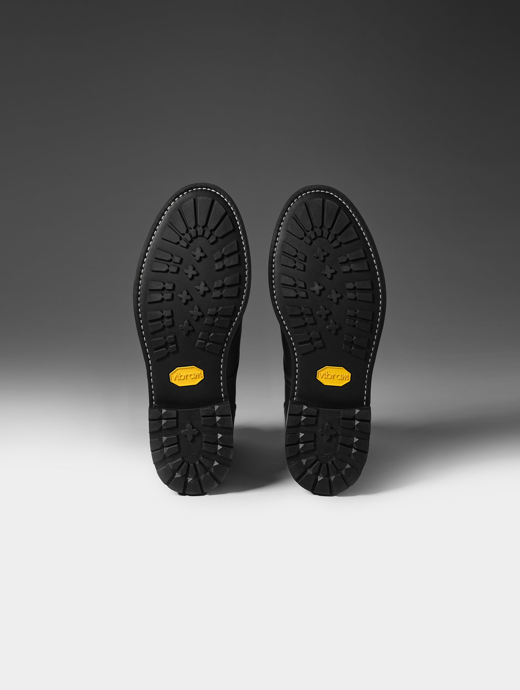 View of the Vibram outsoles on the bottom of the Tioga Moto Boot in Onyx Black from AETHER Apparel.