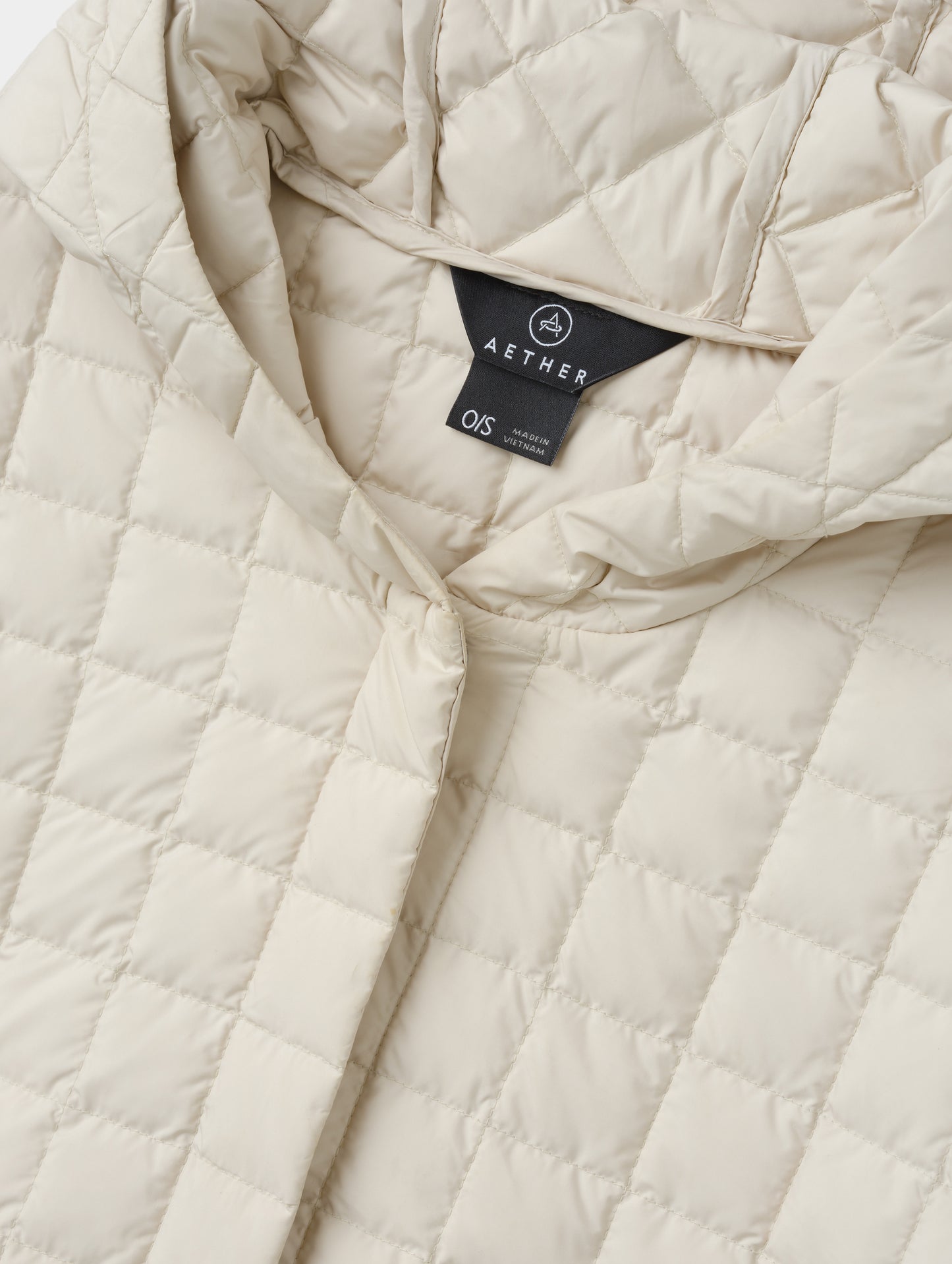 Closeup detailed view of the collar and hidden center-front closure on the Bardo Hooded Poncho in Bone from AETHER Apparel.