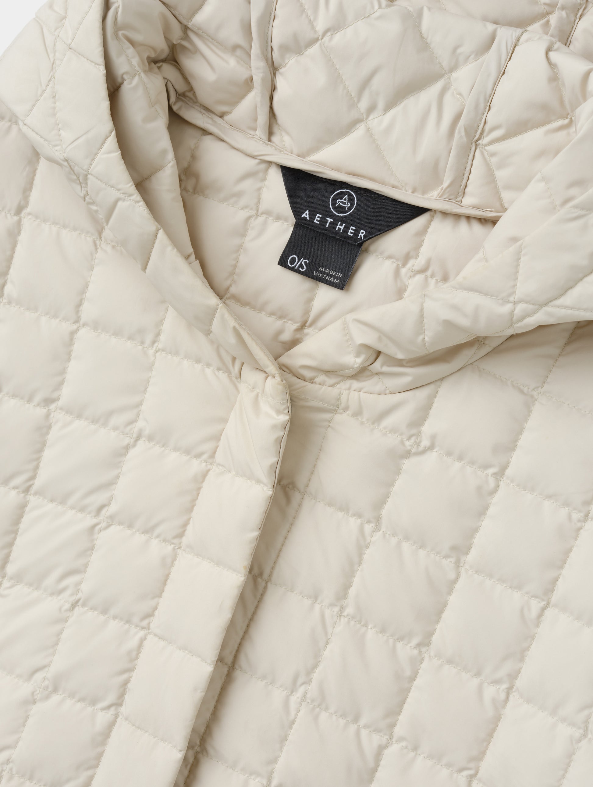 Closeup detailed view of the collar and hidden center-front closure on the Bardo Hooded Poncho in Bone from AETHER Apparel.