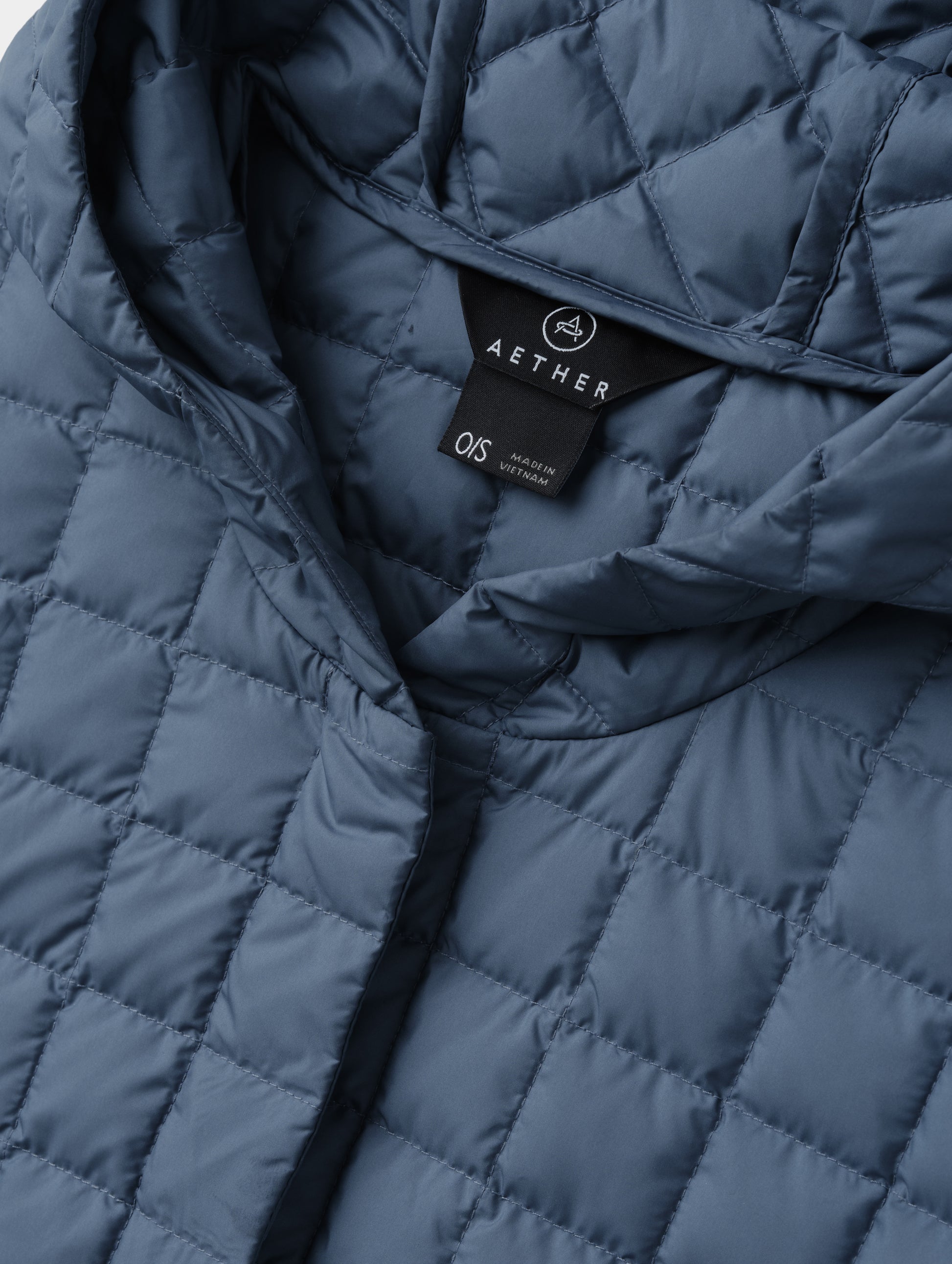Closeup detailed view of the collar and hidden center-front closure on the Bardo Hooded Poncho in Portal Blue from AETHER Apparel.