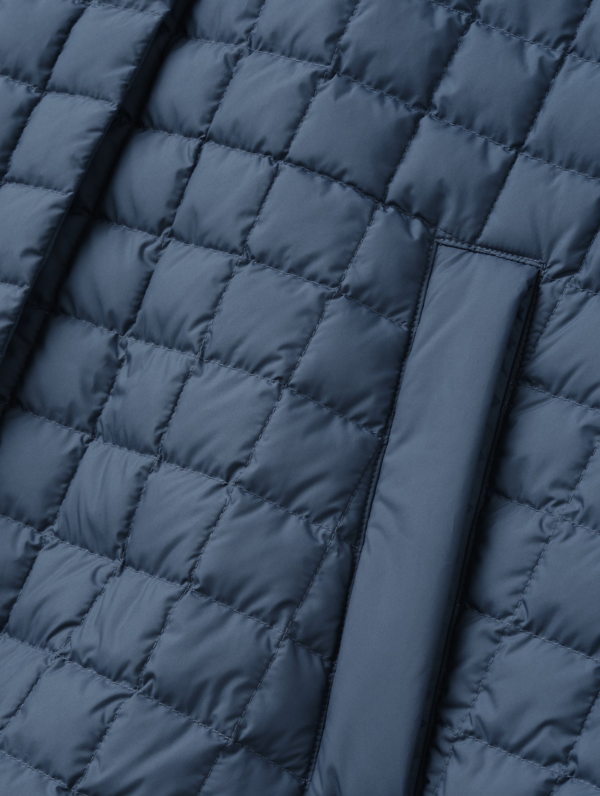 Closeup detailed view of the hand pockets on the Bardo Hooded Poncho in Portal Blue from AETHER Apparel.