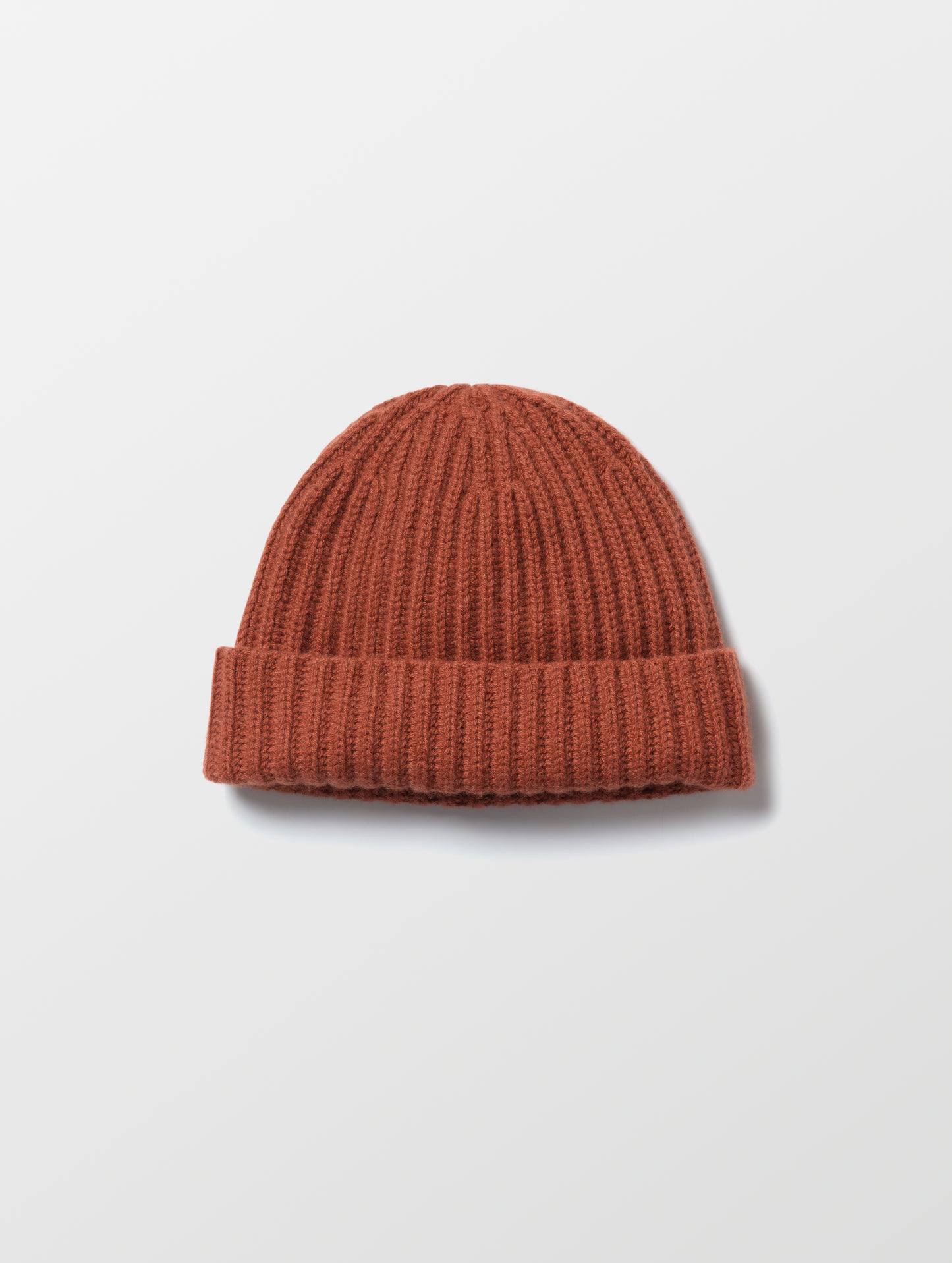 Flat lay of the Cashmere Hat in Redwood Rust from AETHER Apparel. 