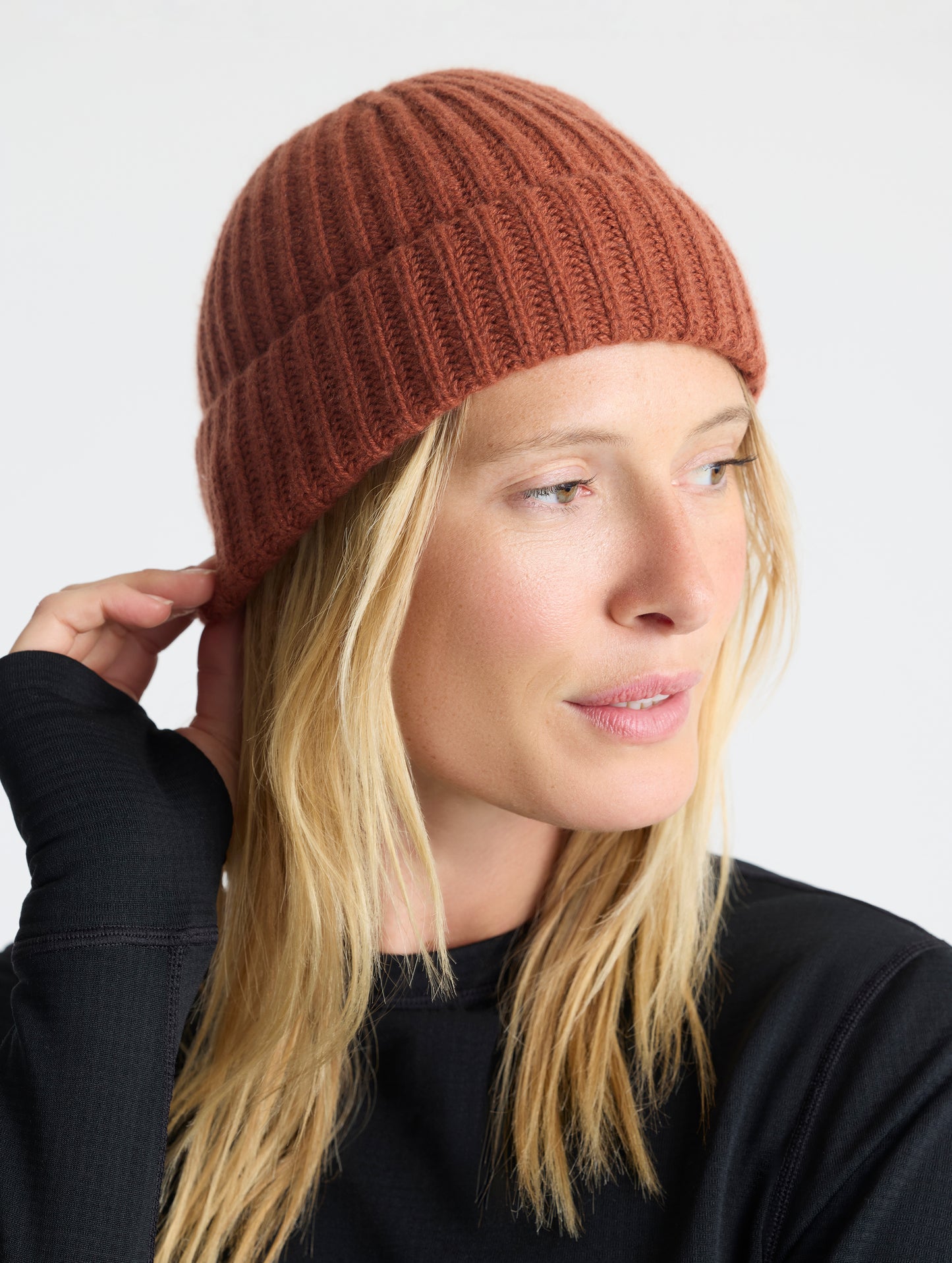 Front right angled view of woman wearing the Cashmere Hat in Redwood Rust from AETHER Apparel. 