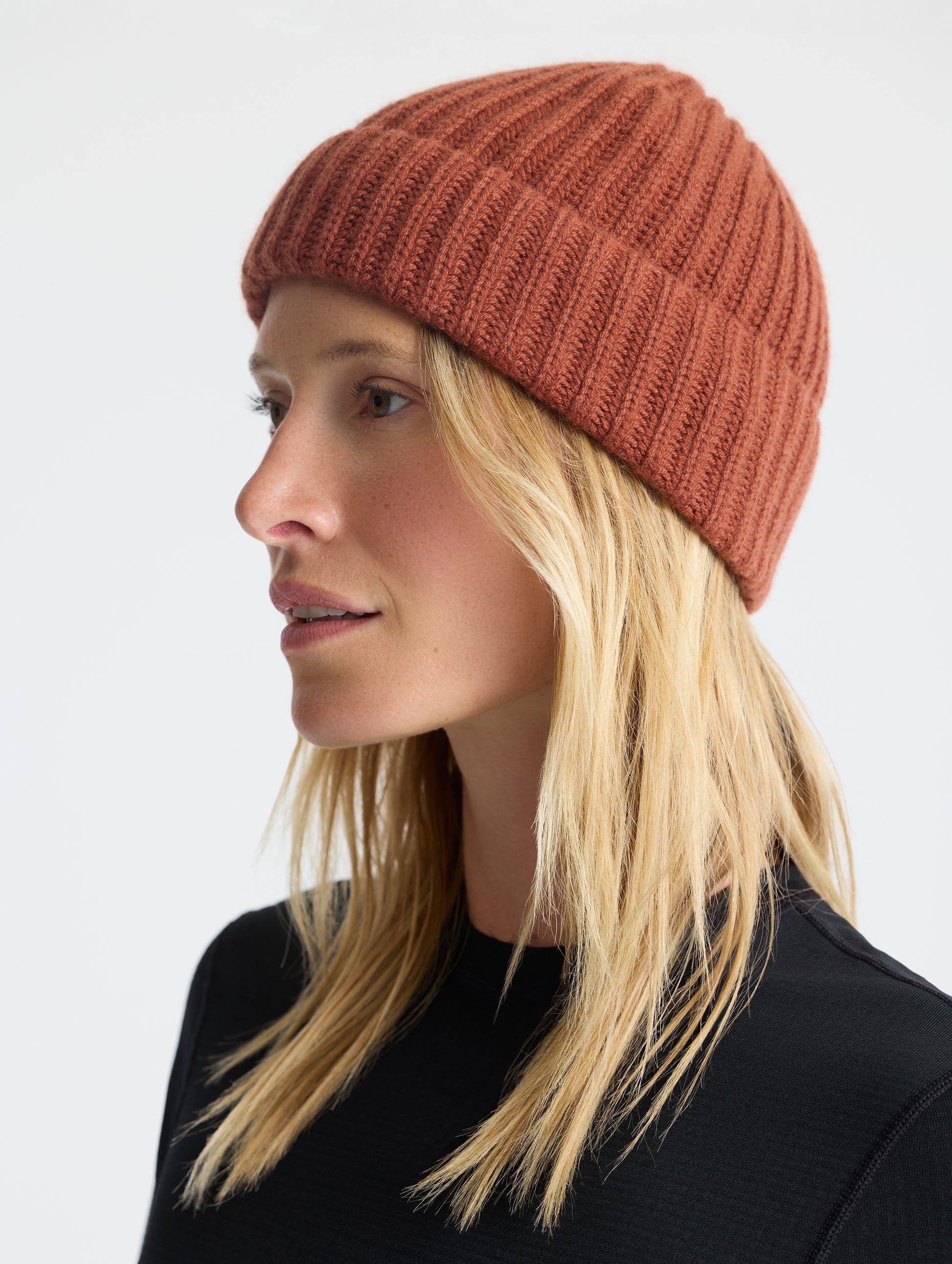 Front left angled view of woman wearing the Cashmere Hat in Redwood Rust from AETHER Apparel. 