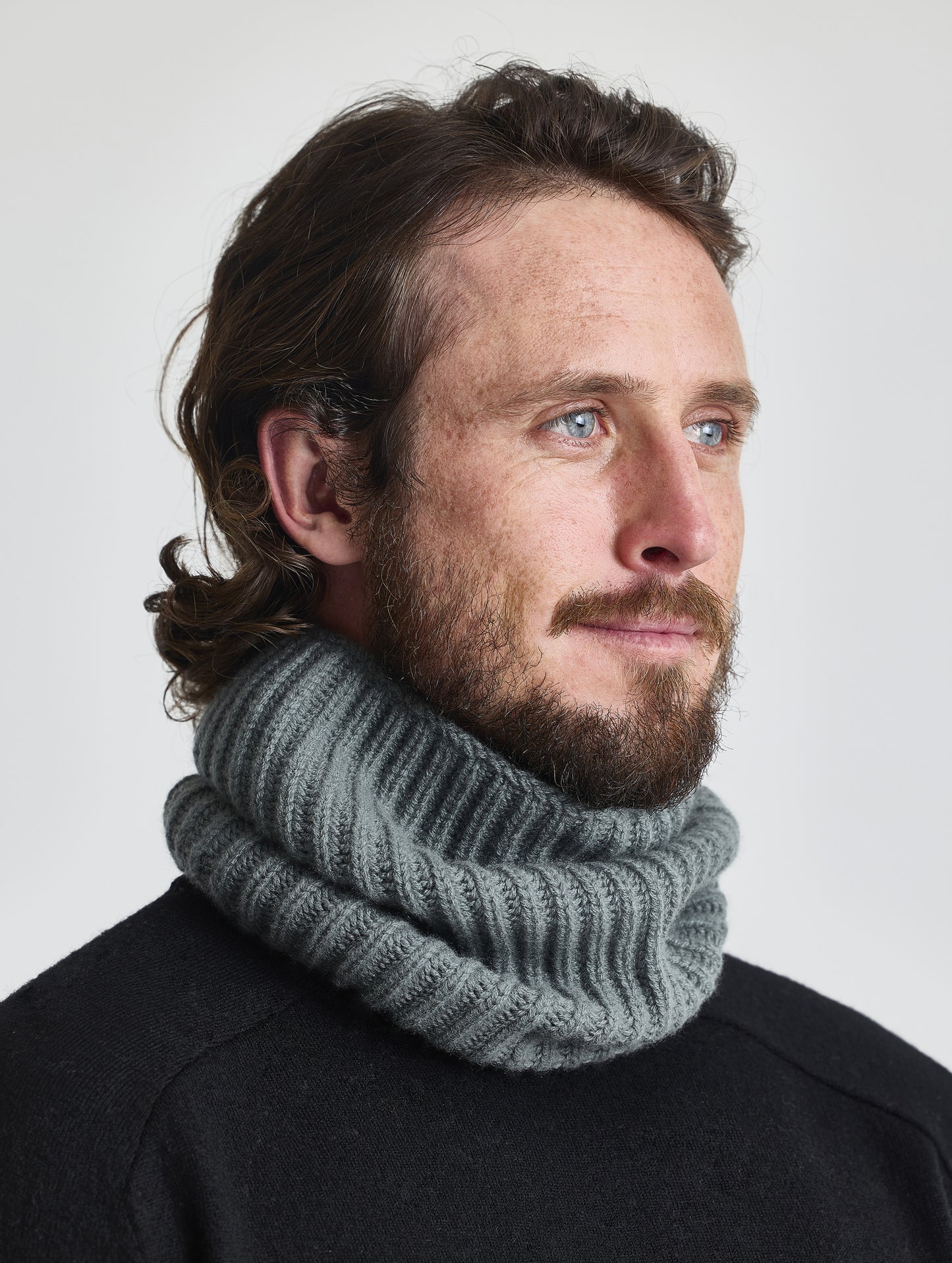 Front left angled view of man wearing the Cashmere Neck Gaiter in Gunmetal from AETHER Apparel. 