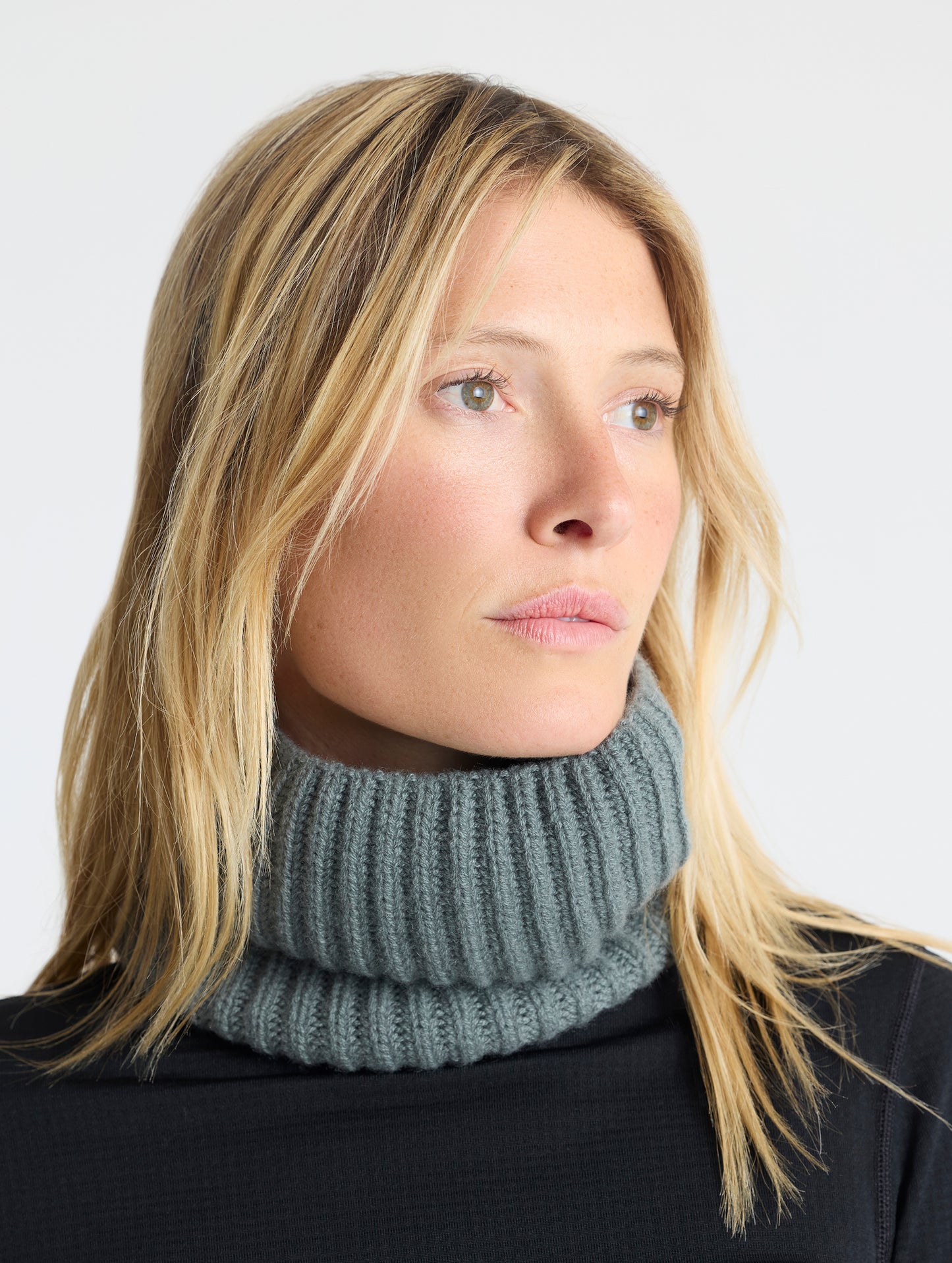 Front angled view of woman wearing the Cashmere Neck Gaiter in Gunmetal from AETHER Apparel. 