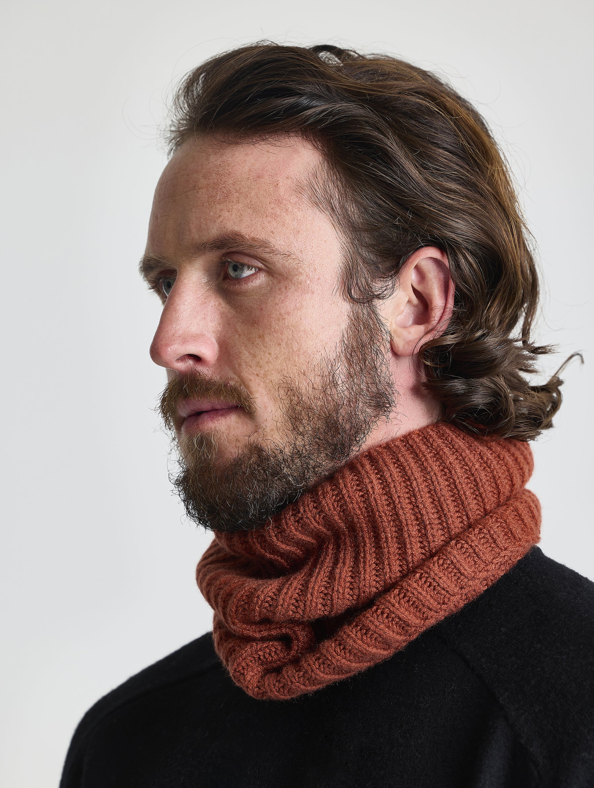 Front angled view of man wearing the Cashmere Neck Gaiter in Redwood Rust from AETHER Apparel. 