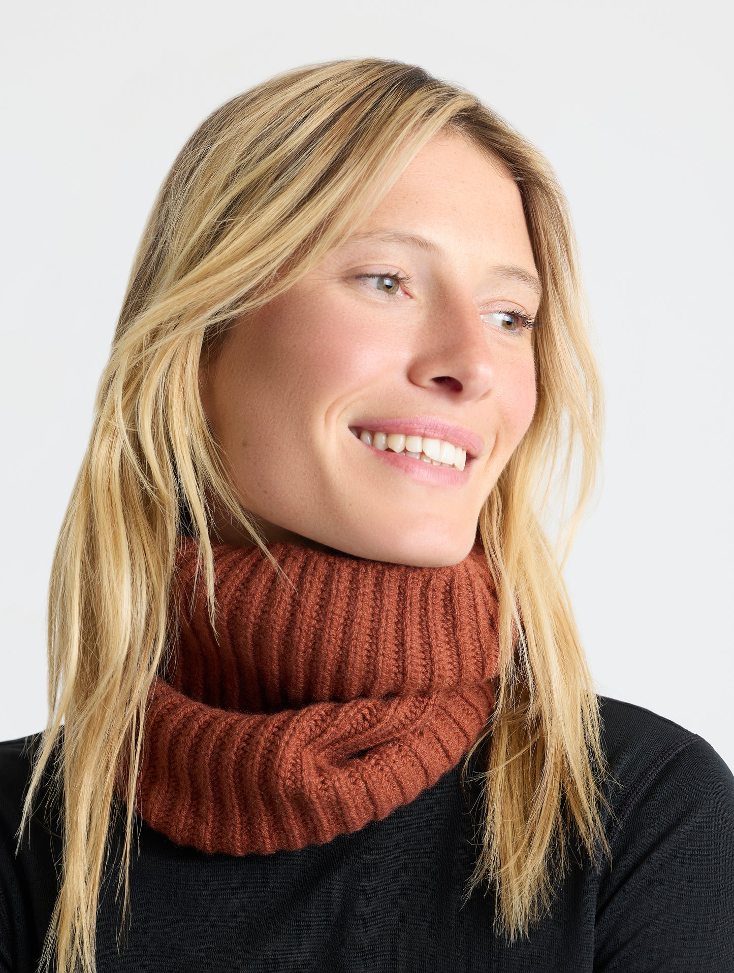Front angled view of woman wearing the Cashmere Neck Gaiter in Redwood Rust from AETHER Apparel. 