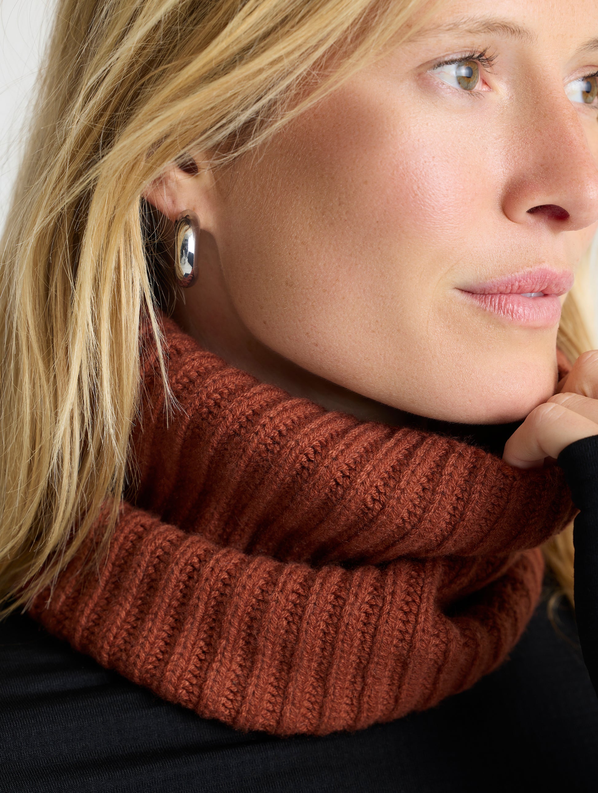 Closeup front angled view of woman wearing the Cashmere Neck Gaiter in Redwood Rust from AETHER Apparel. 
