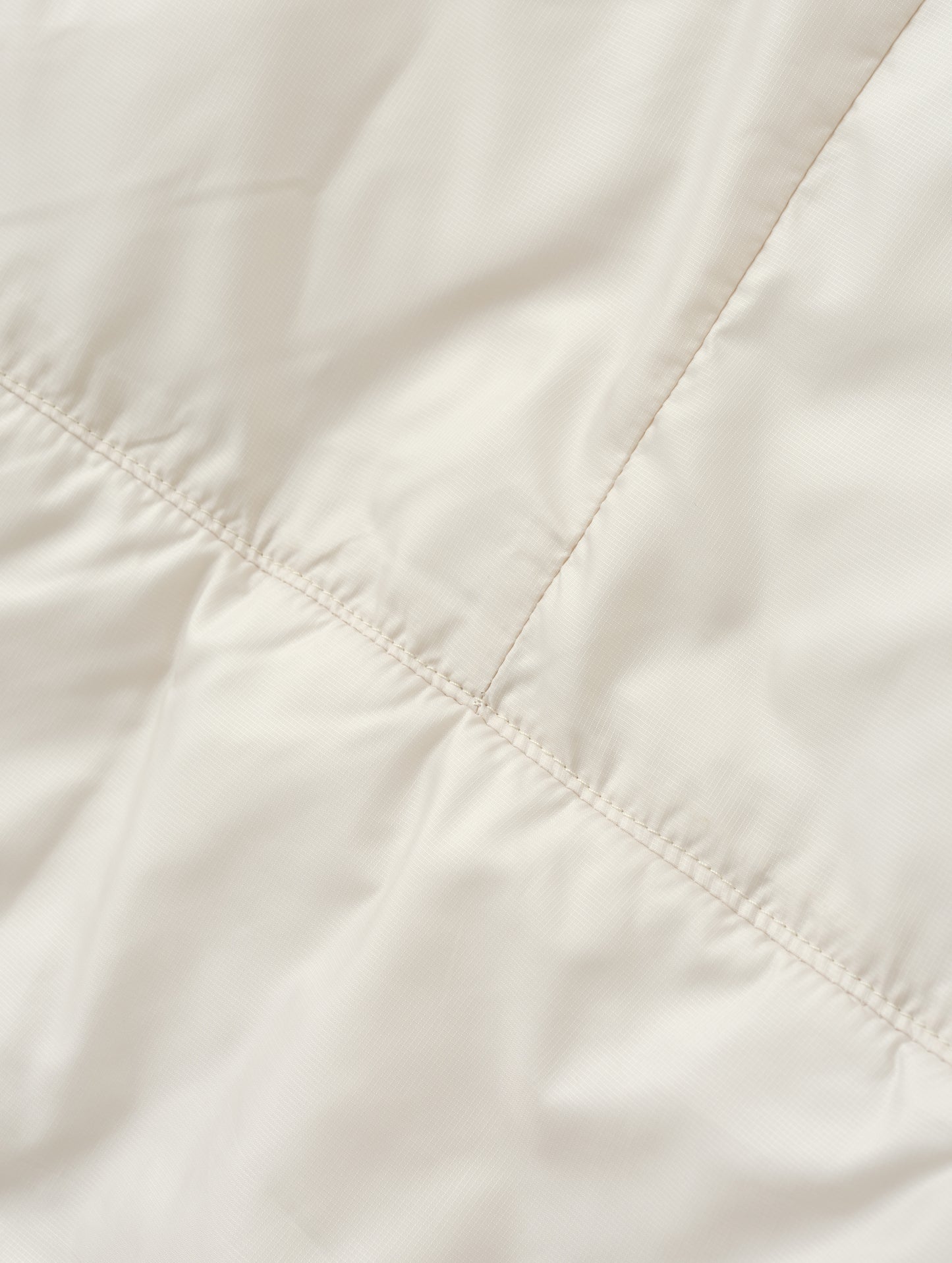 Closeup detailed view of the back seam on the Celeste Eco Insulated Hoodie in Bone from AETHER Apparel.